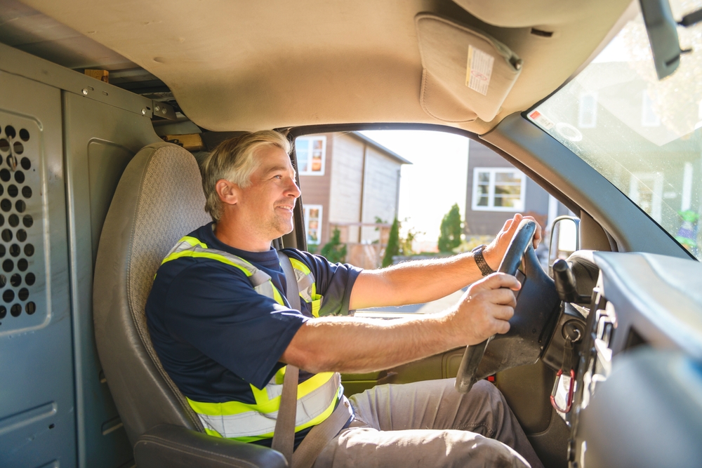 A happy mature professional driver driving a truck