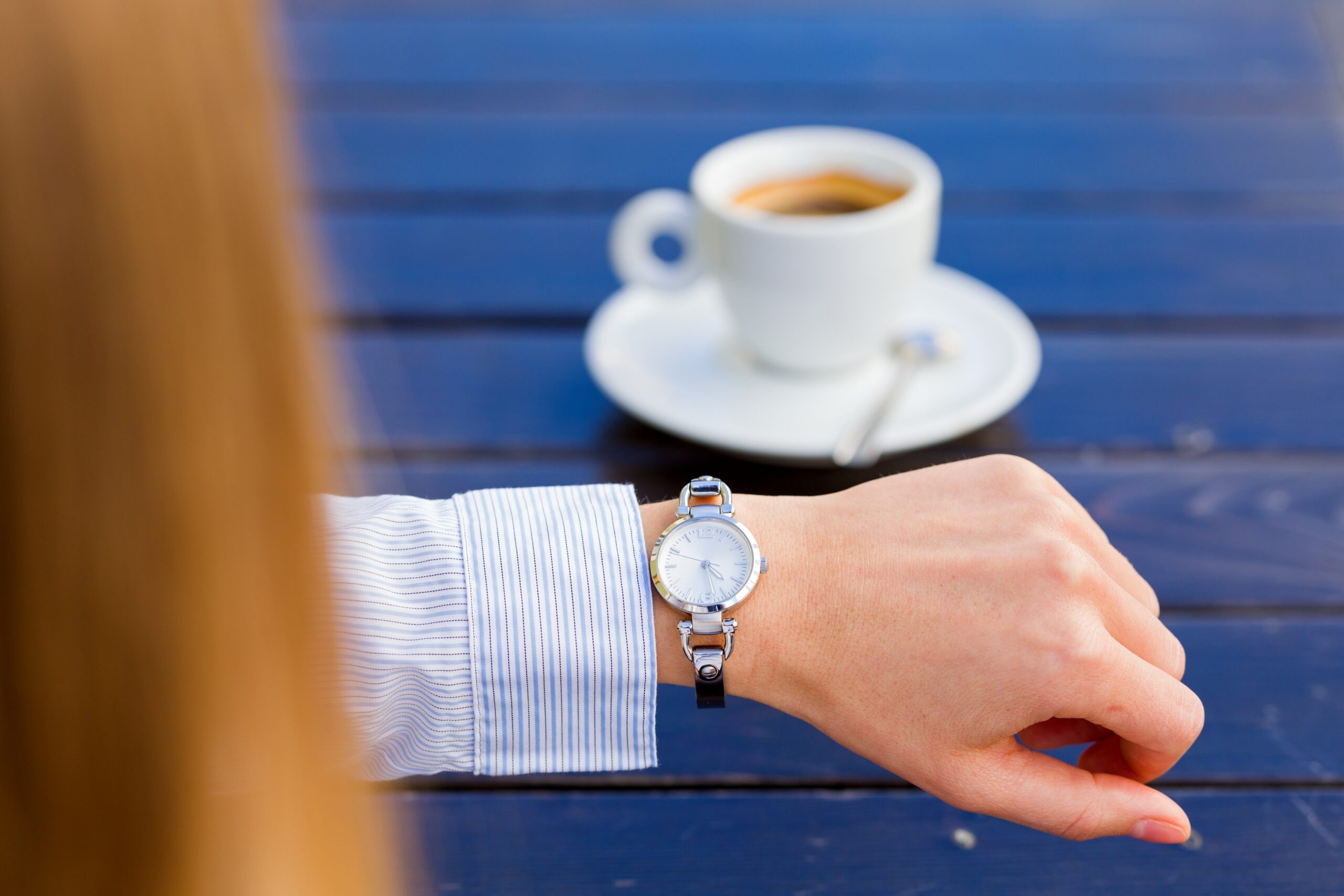 A woman early for a meeting and looking at her watch.