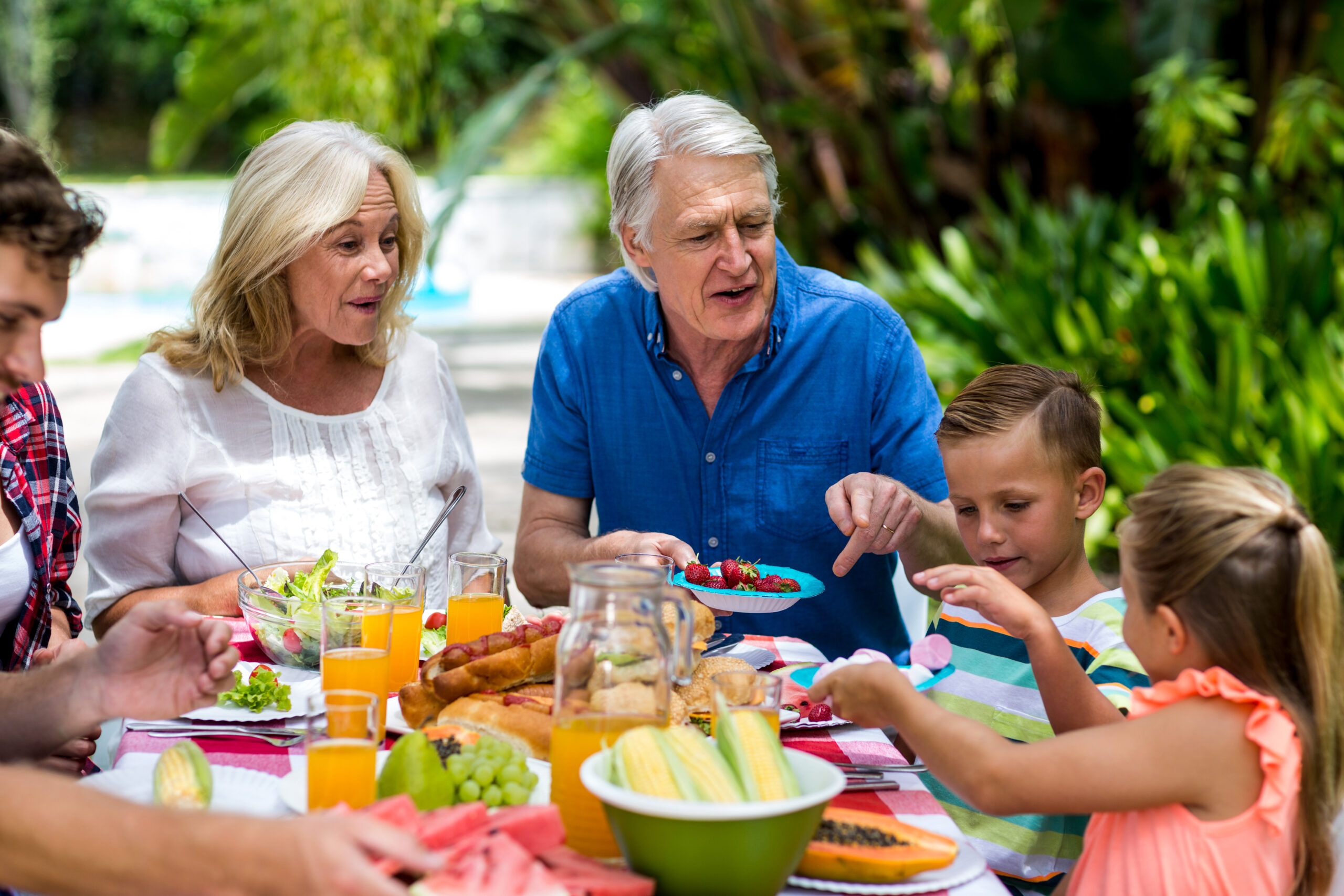 Grandparents teaching a lesson to their grandchildren about table manners.