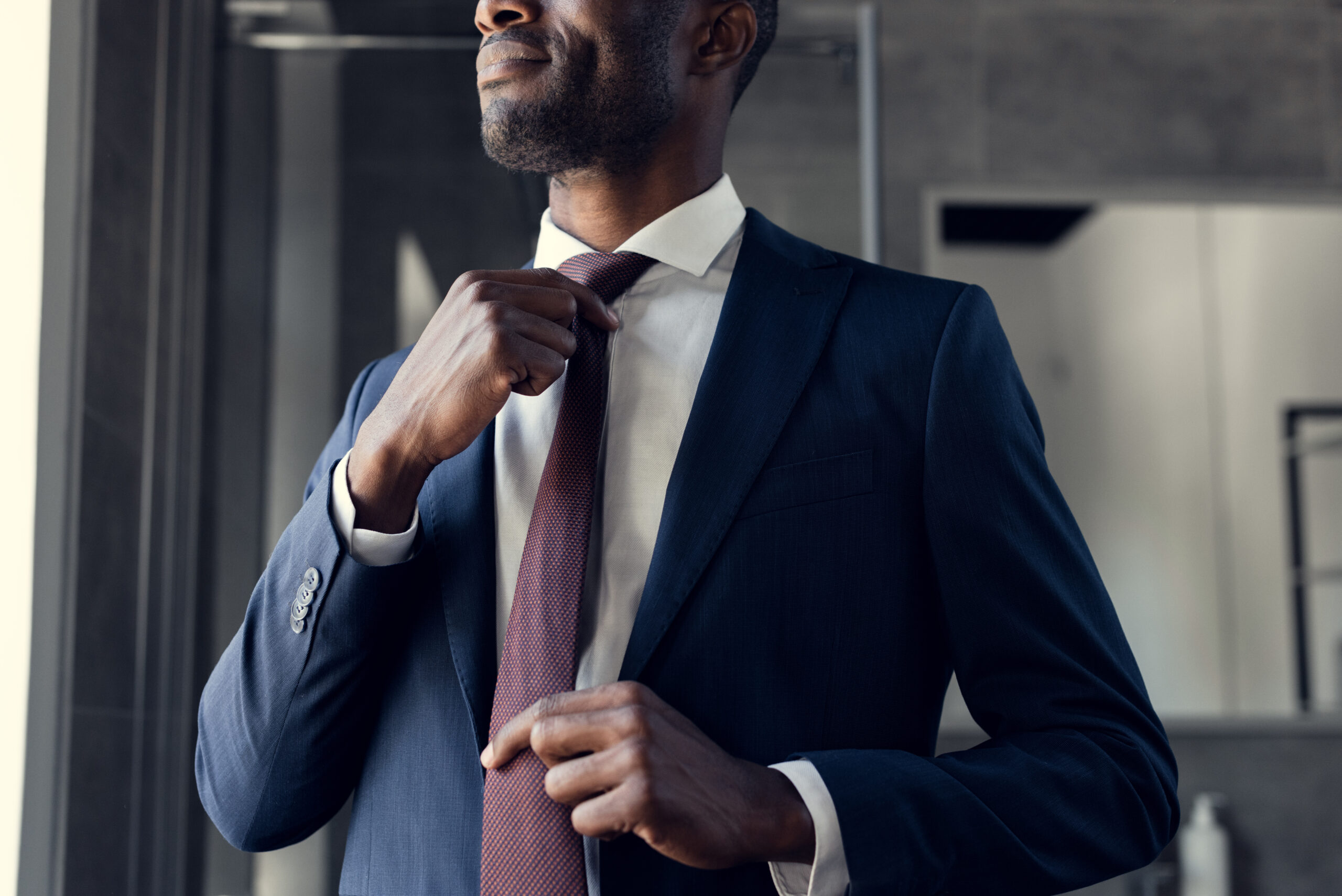A young businessman putting on his tie.