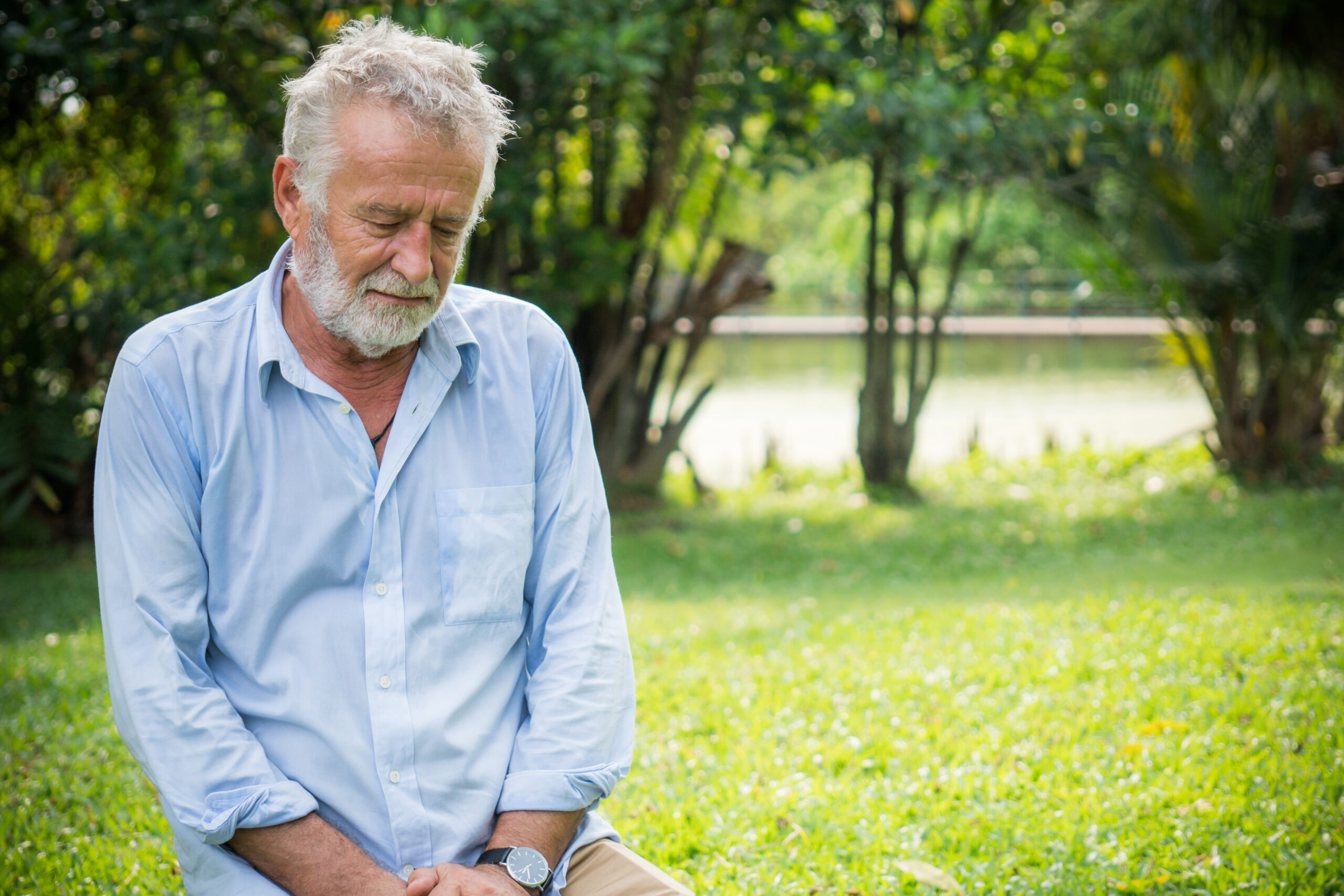 A pensive elderly male sitting alone.