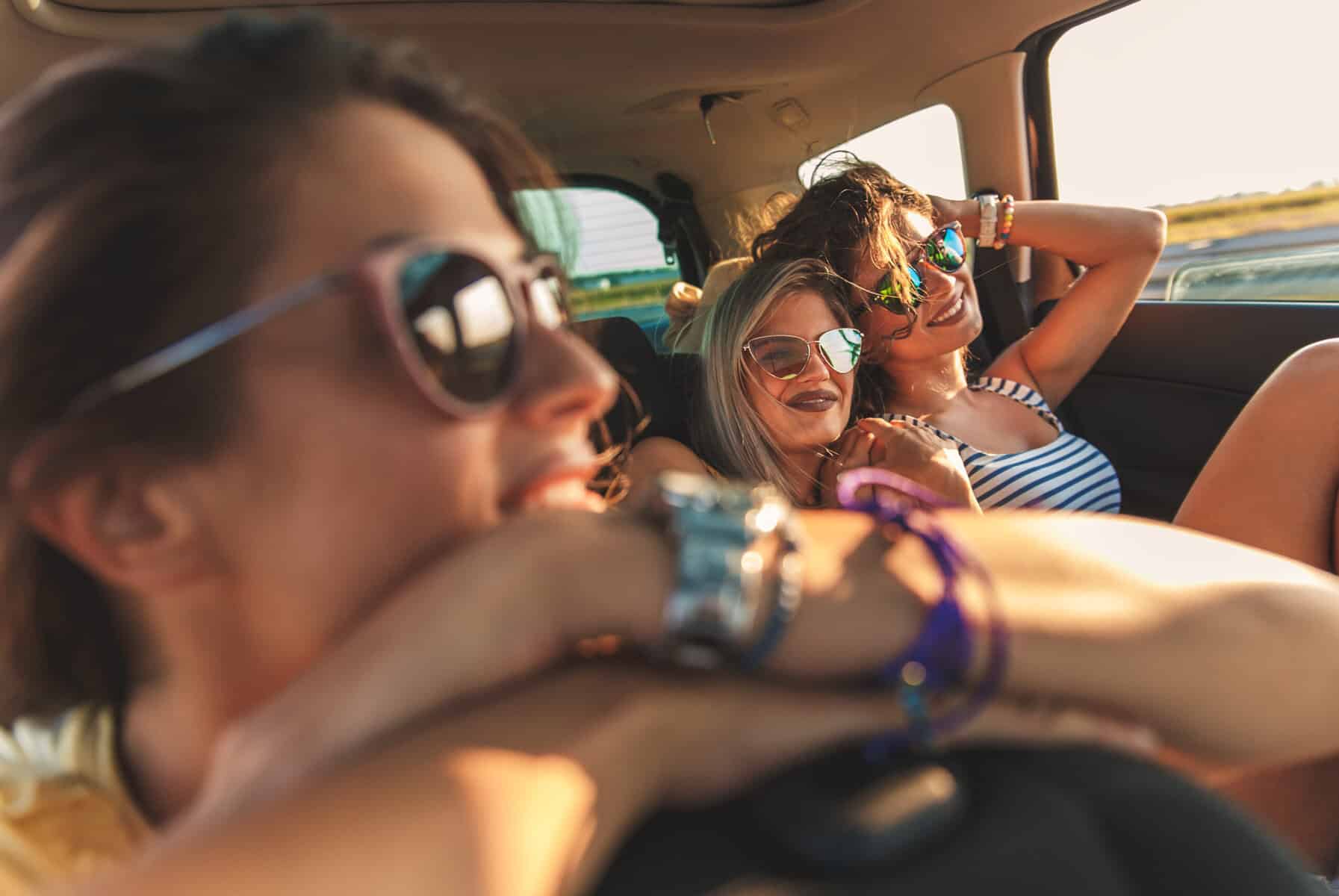 Three female friends enjoying a road trip together.