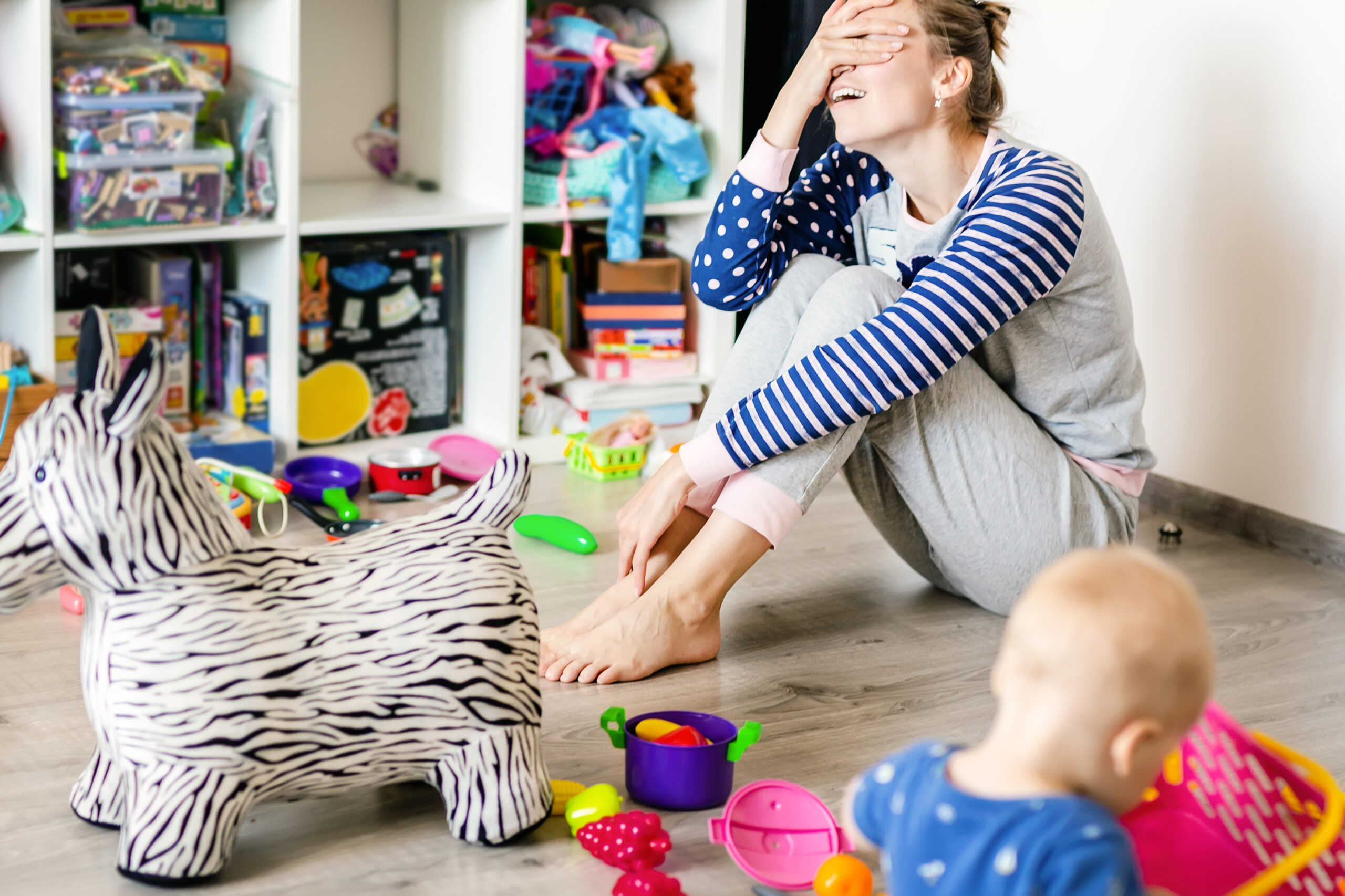 Tired of everyday household mother sitting on the floor with her baby.