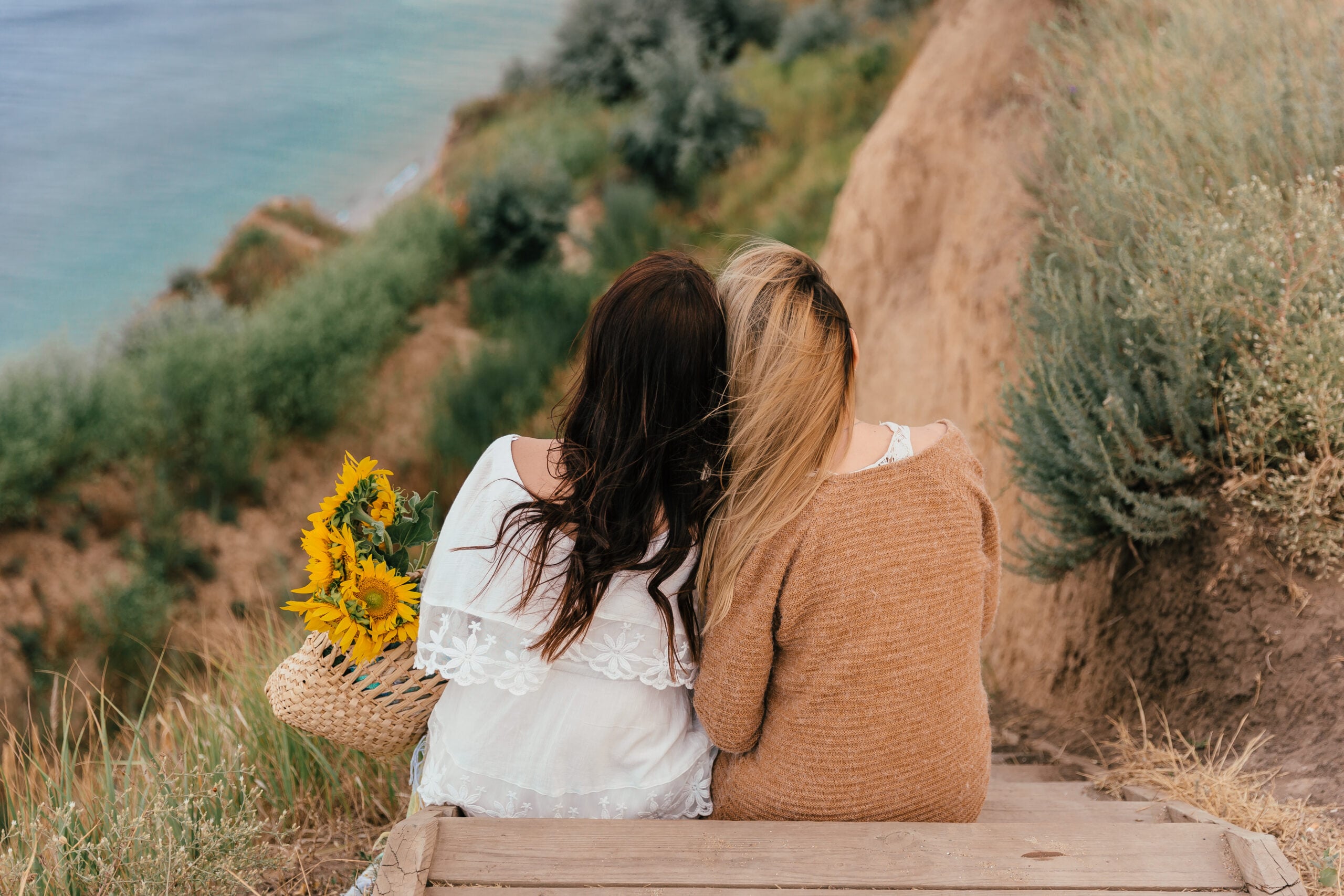 Girlfriends siting together by the sea.