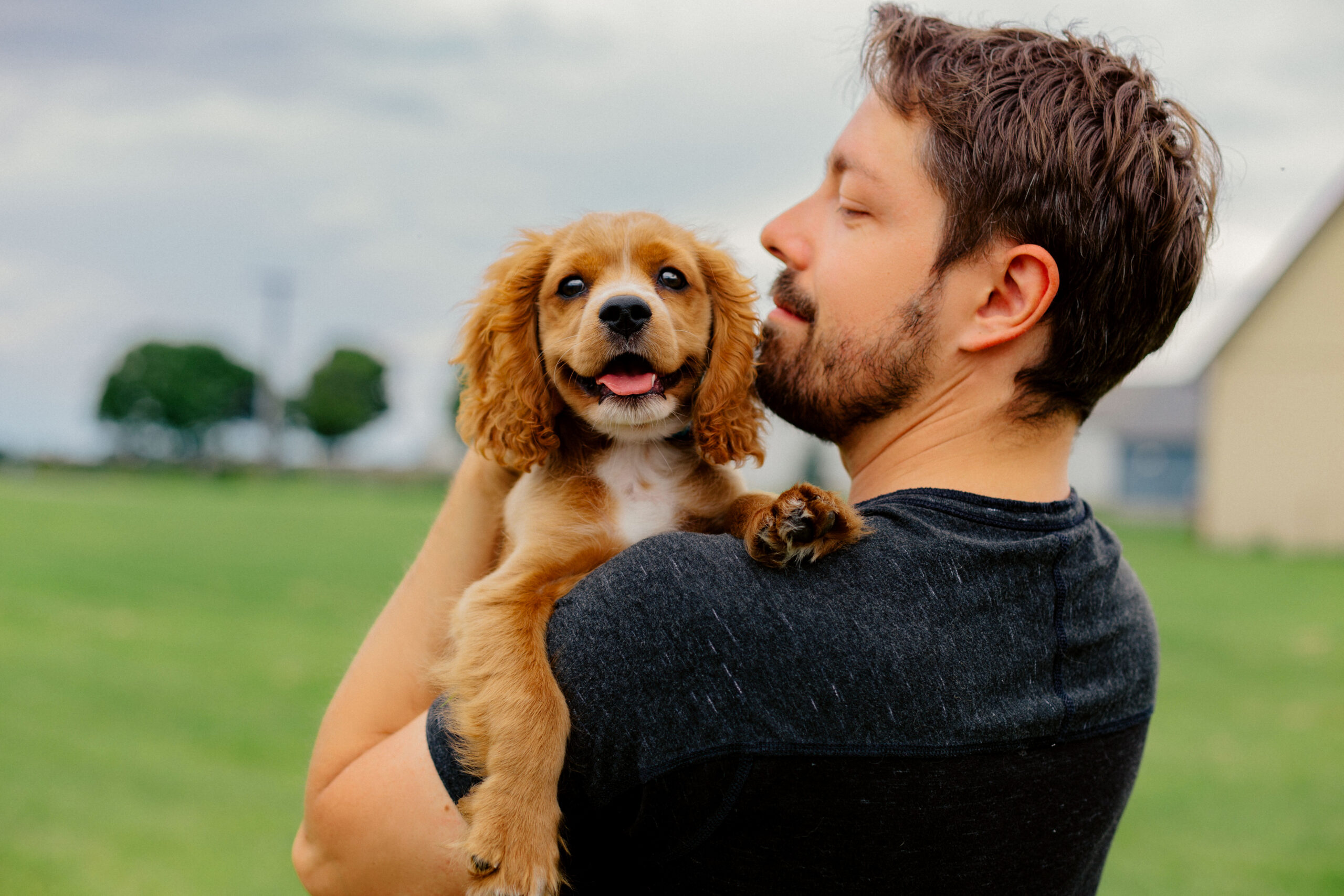 Man holding his cocker spaniel puppy outside.