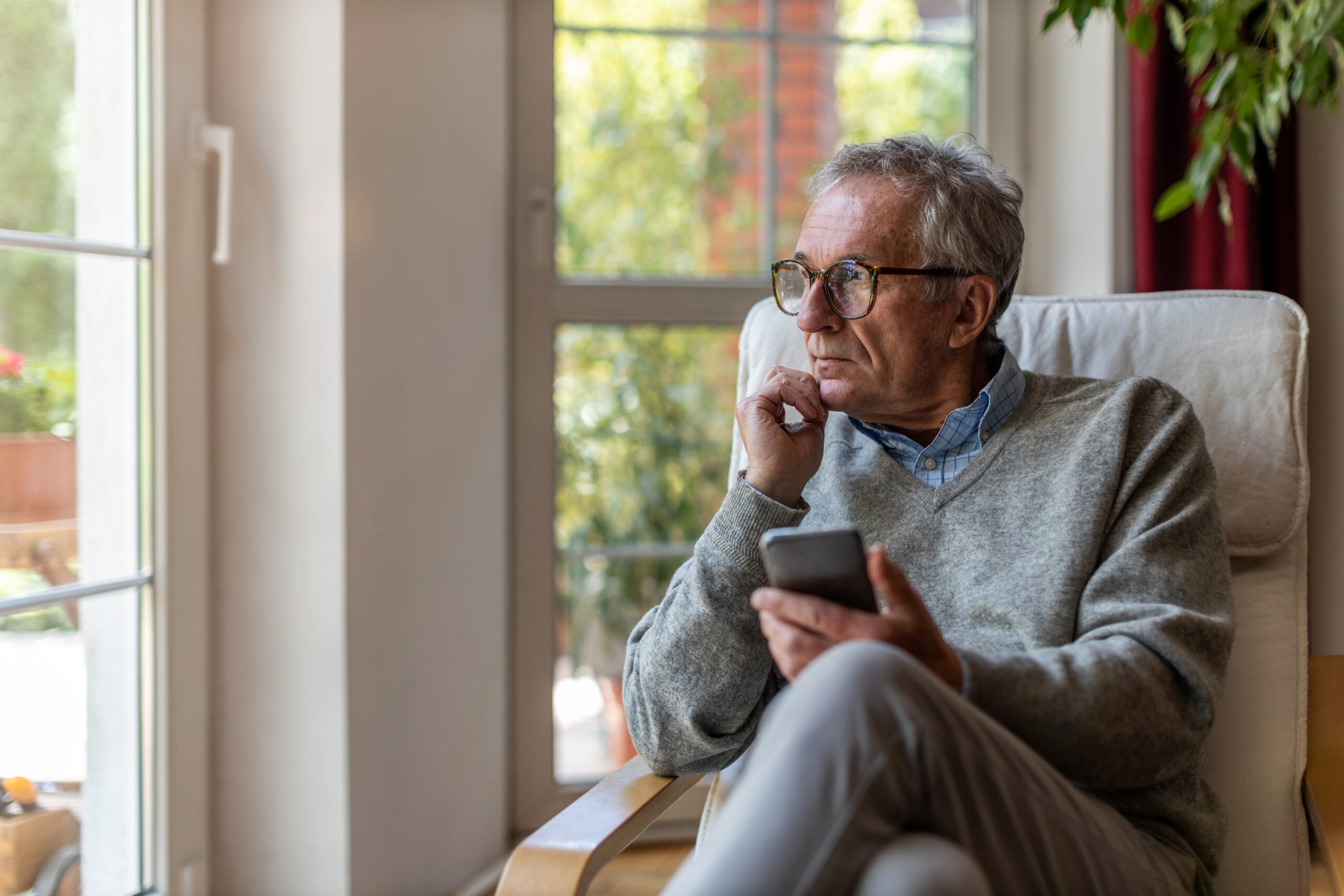 A middle aged man sitting alone at home.