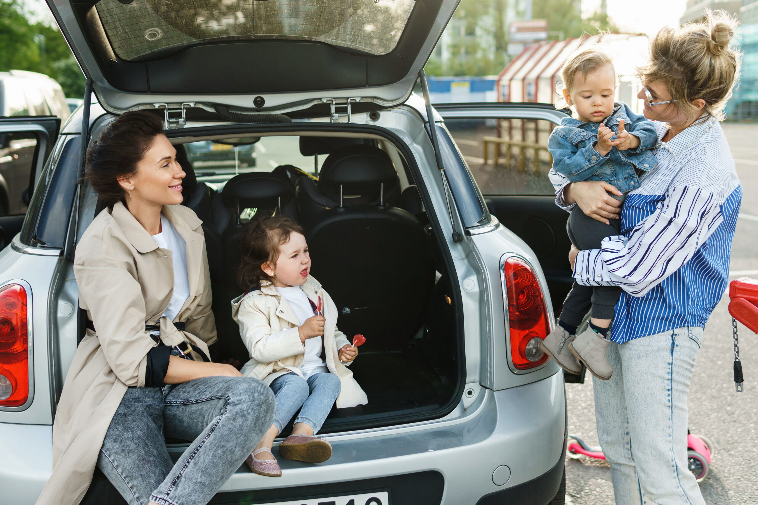 Two women organizing a carpool with their children.