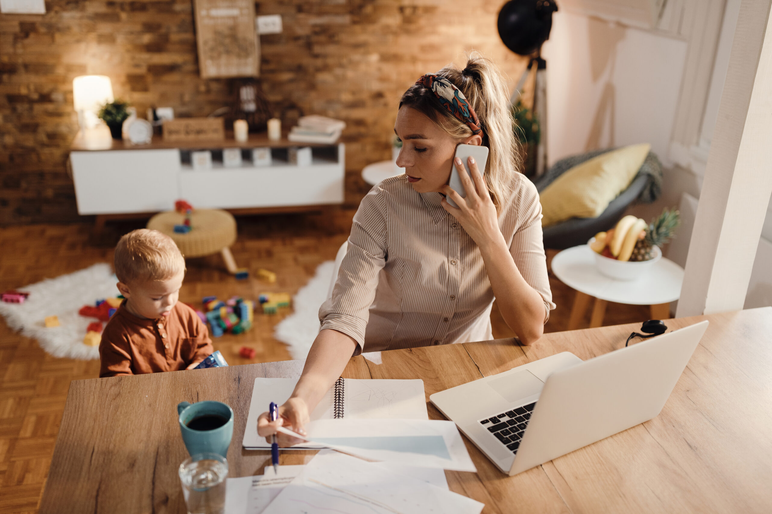 An overwhelmed mother trying to work from home with her toddler.