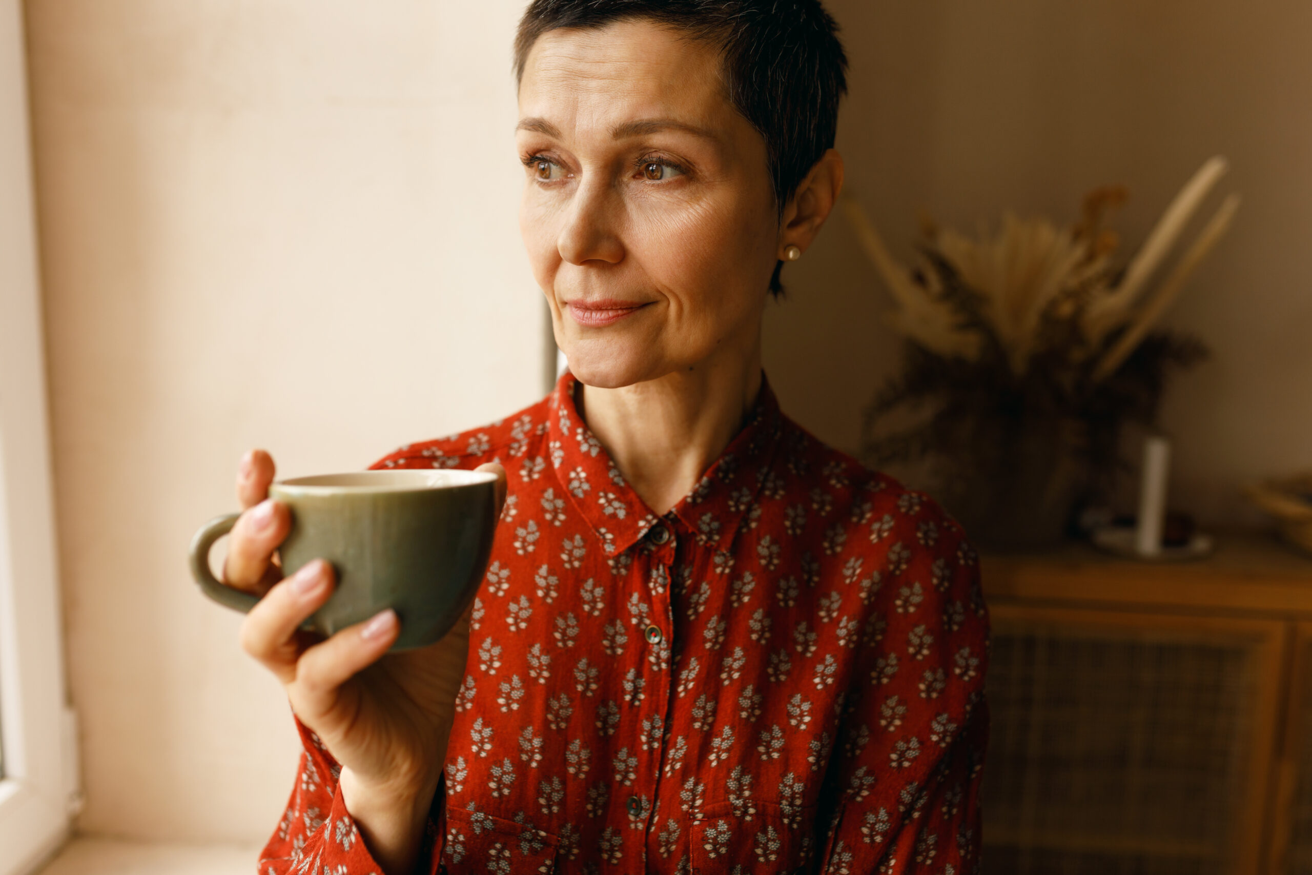 A middle aged confident woman having her morning coffee.