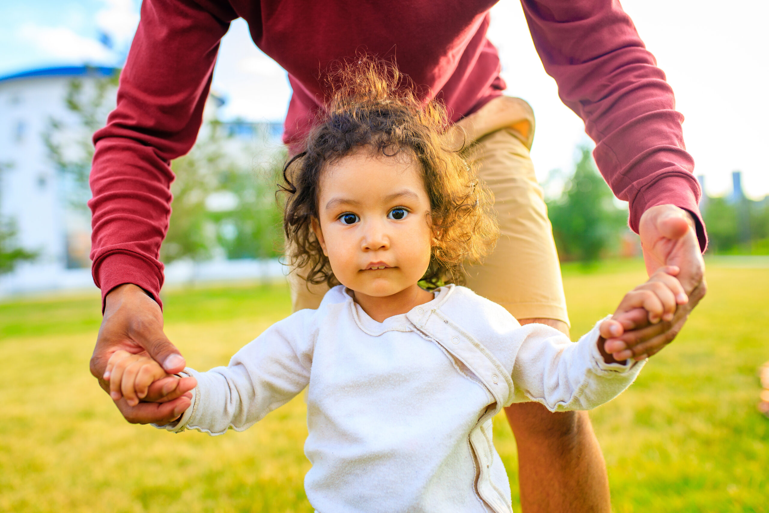A young girl with her father on a walk outside.