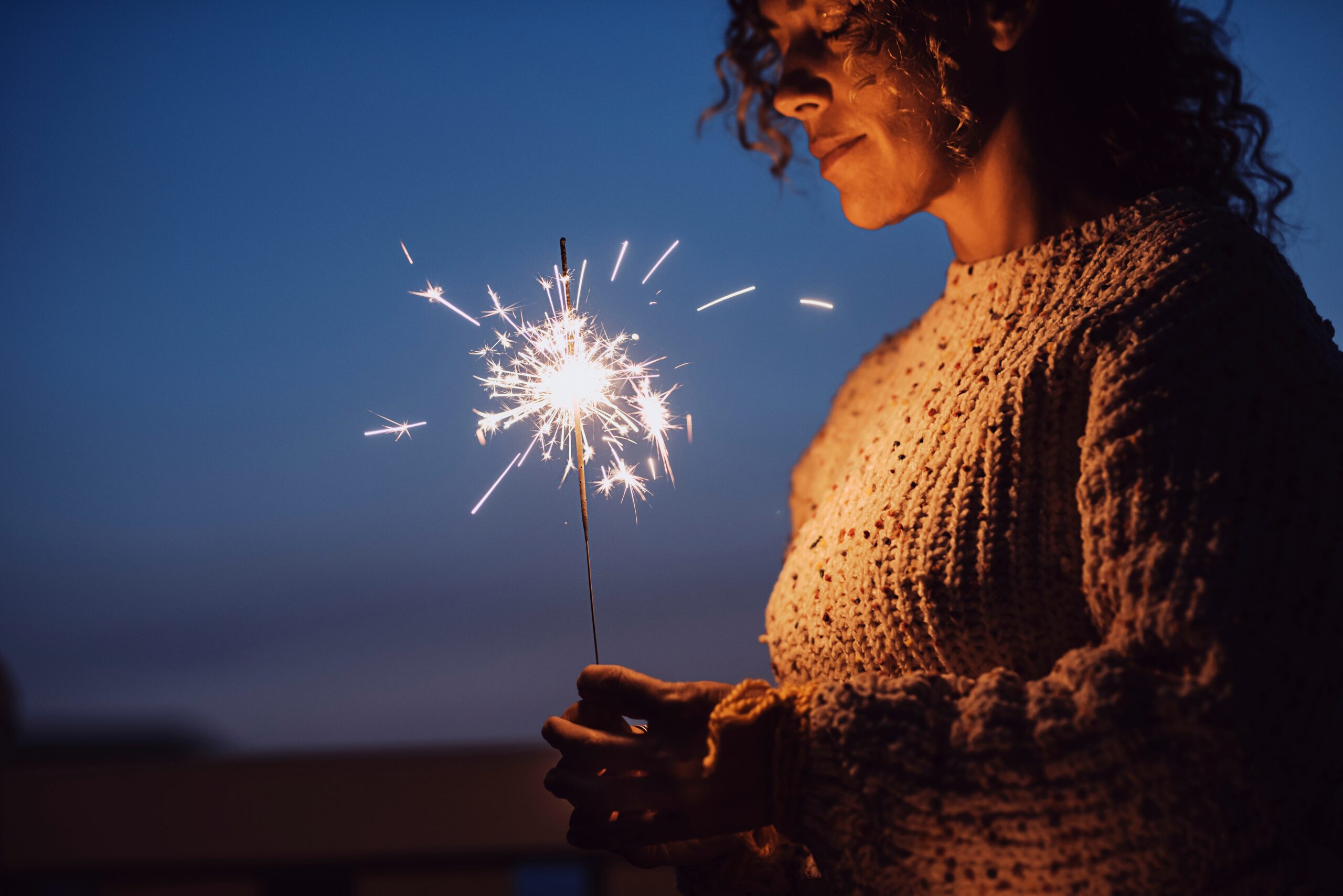 A woman standing alone at a social celebration.
