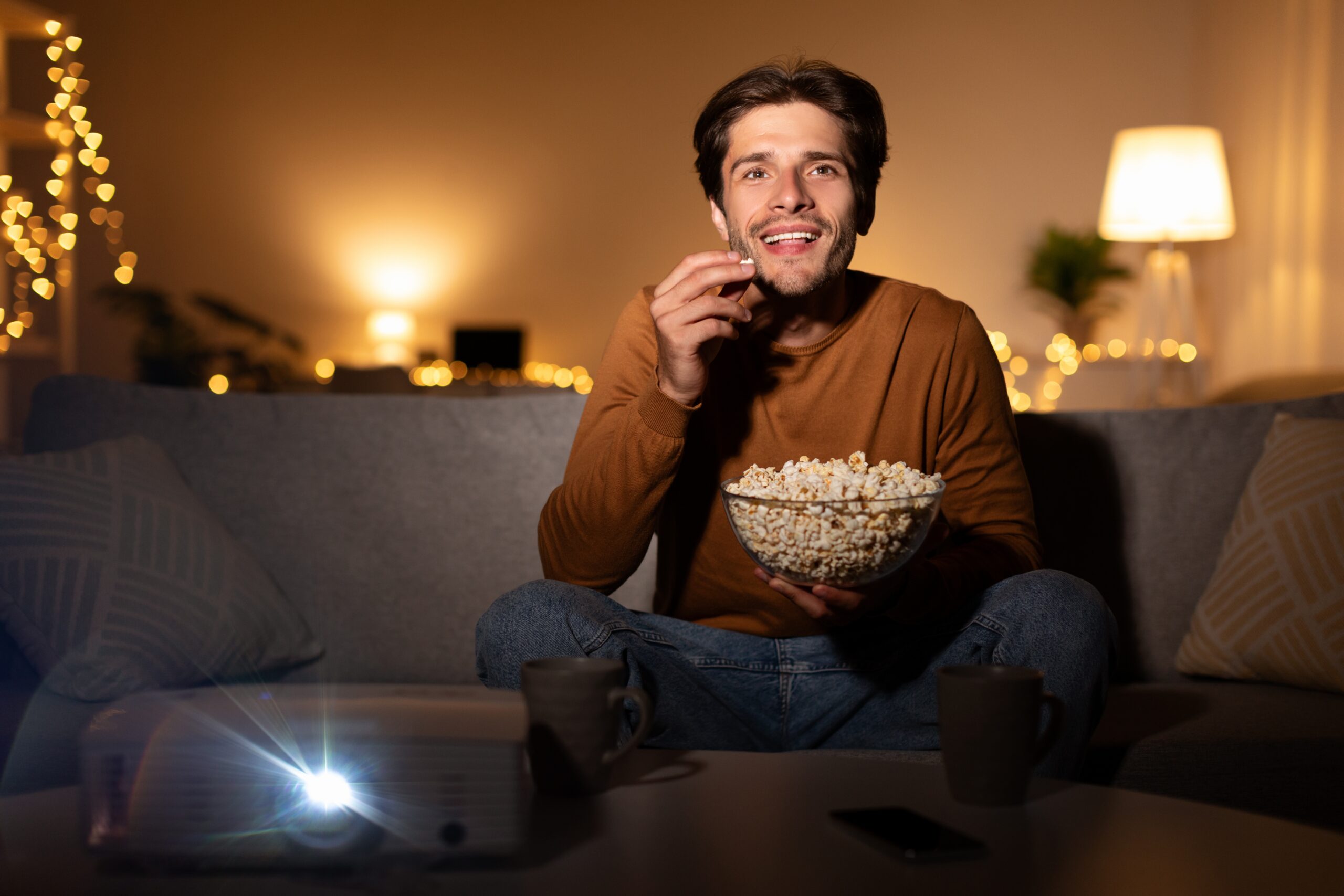 A man enjoying an evening alone watching a movie at home.