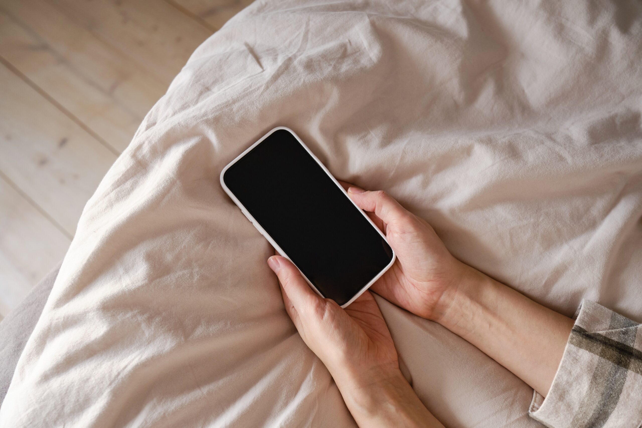 A woman holds a turned off cell phone.