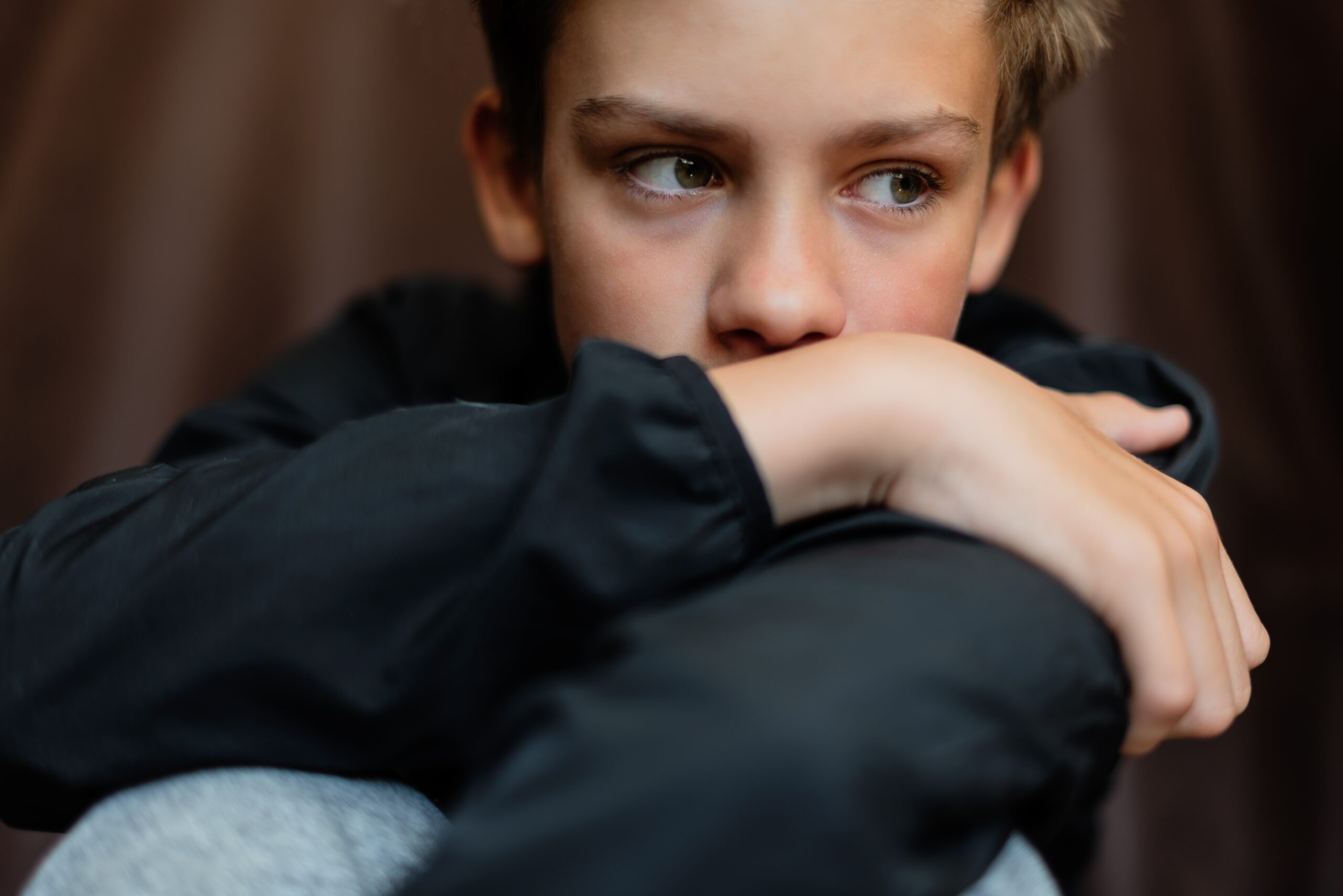 A lonely young boy feeling anxious.