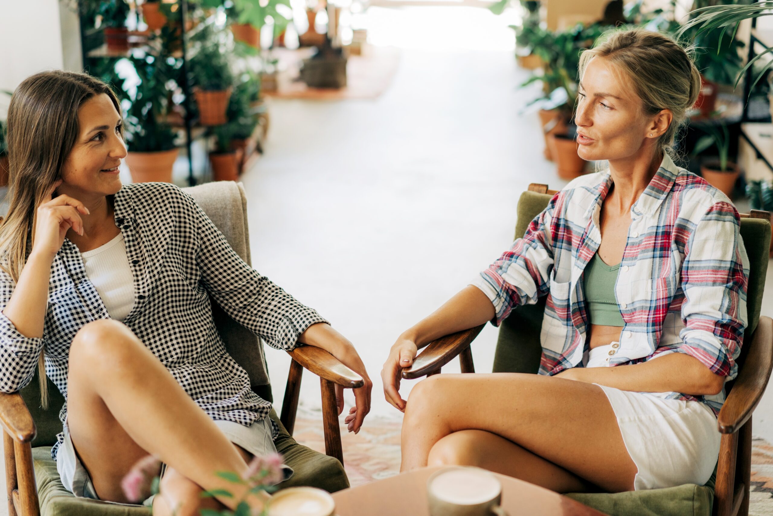 Two women chatting while sitting in a cafe.