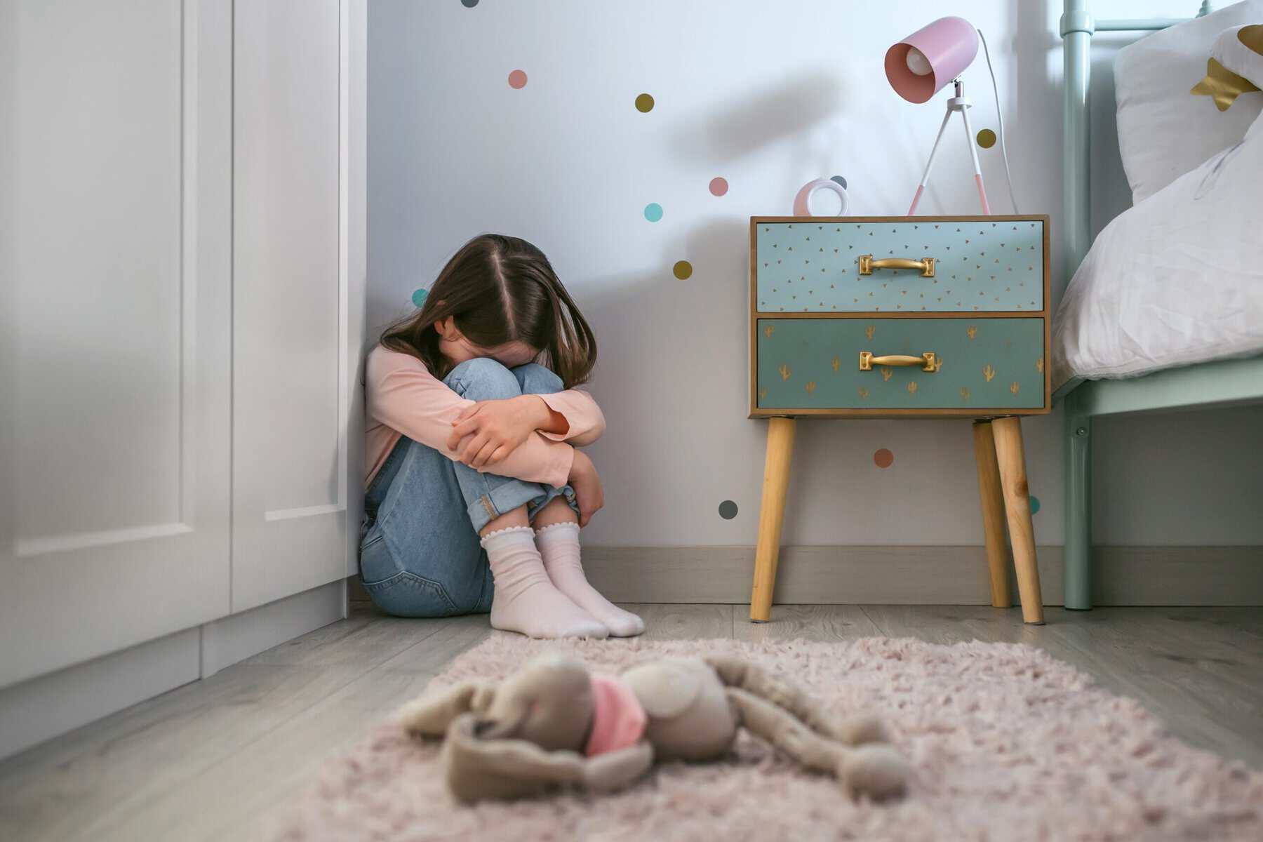 A neglected little girl feeling isolated in her bedroom.
