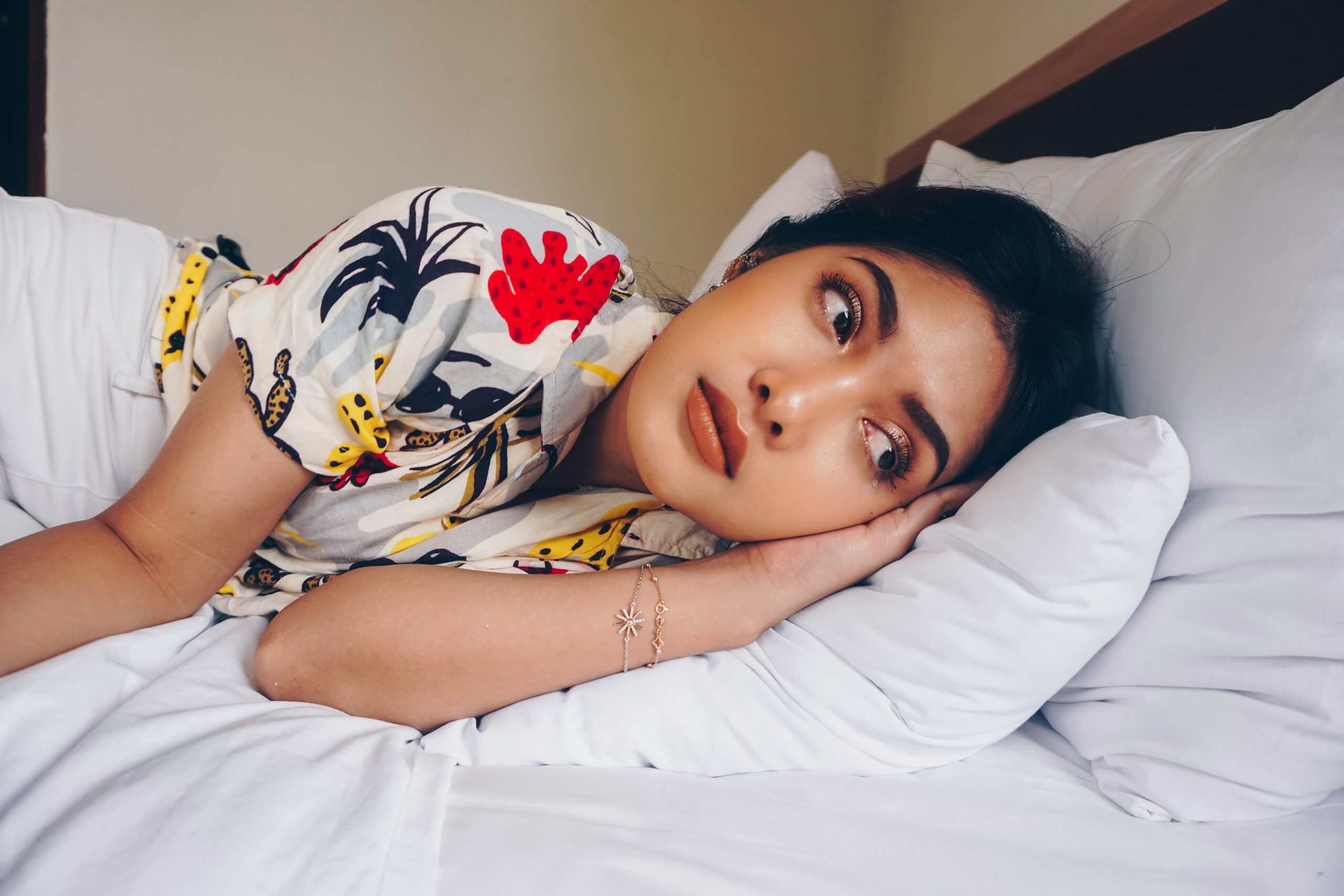 A woman laying in bed over-thinking about her day.