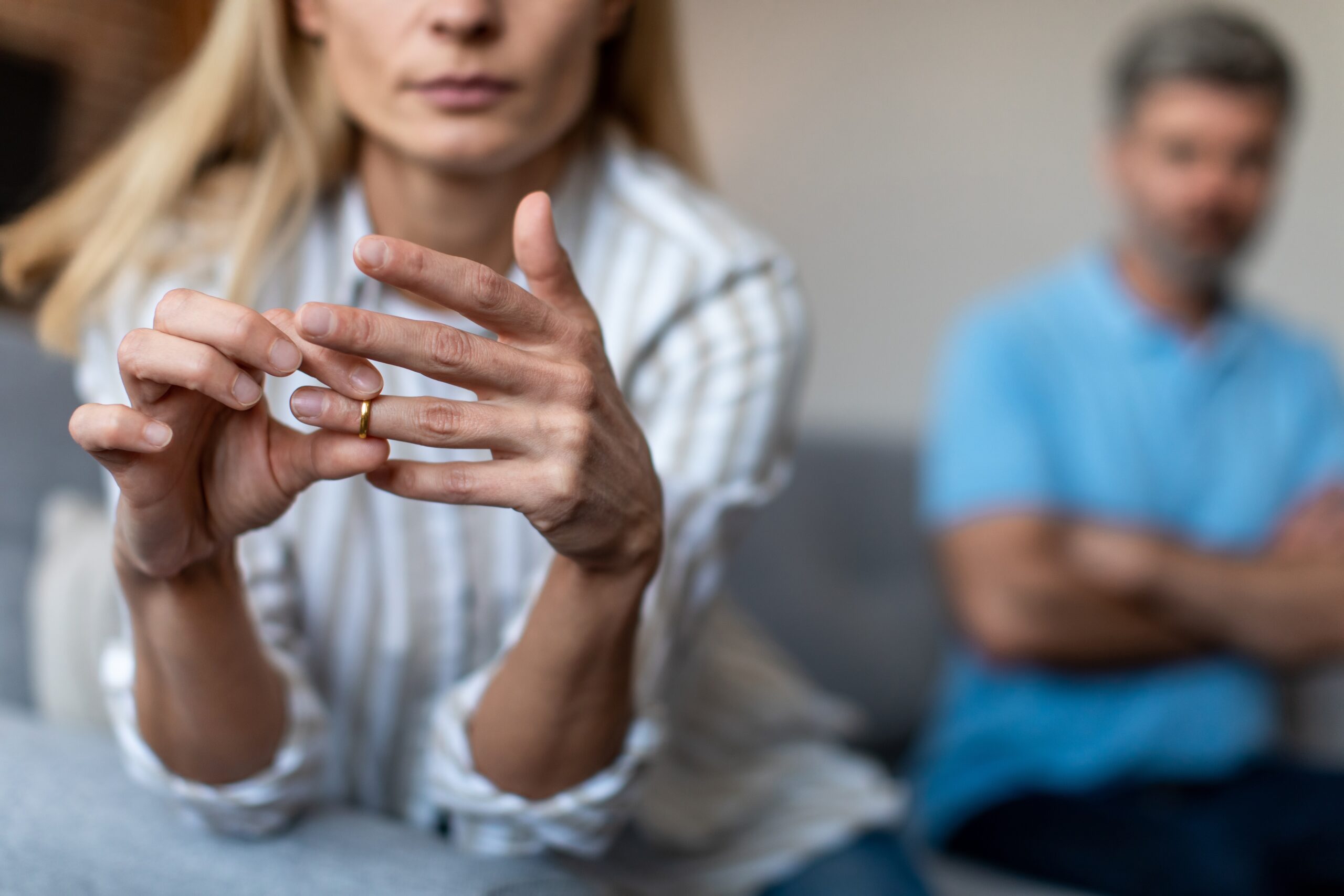 An unhappy middle aged woman removing her wedding band.