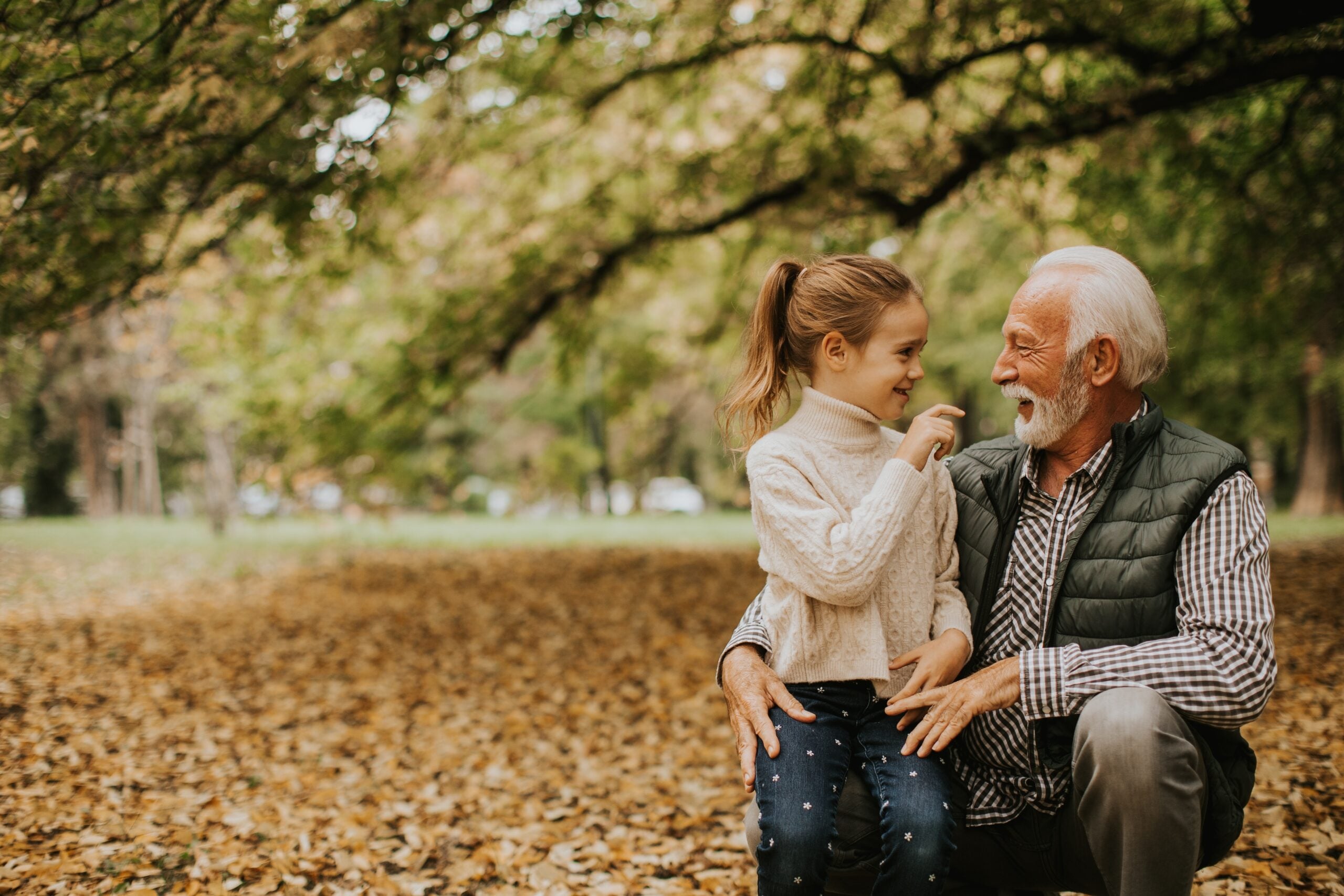 A grandfather spending time with his granddaughter in the park.