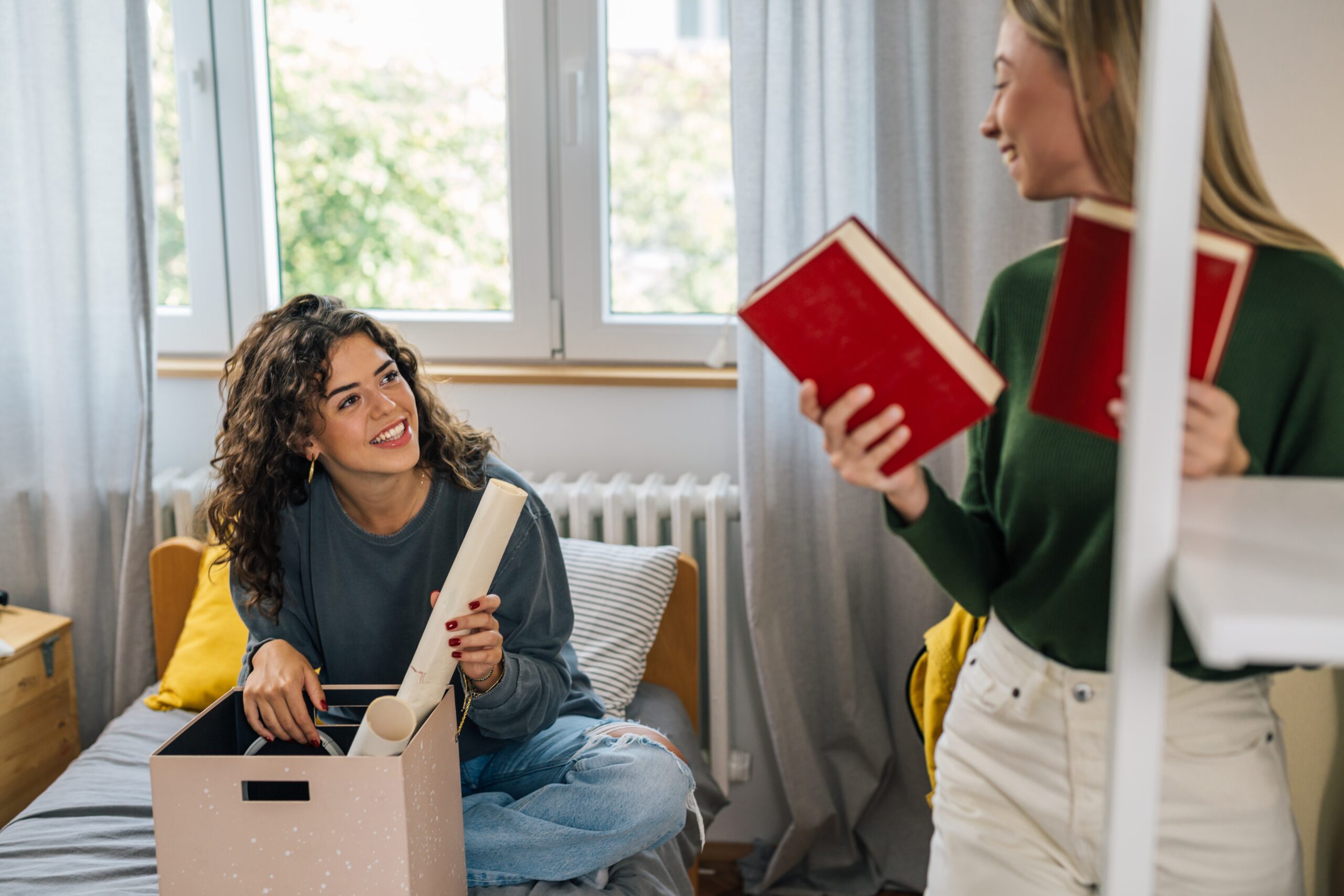 Two women moving into their college dorm room.