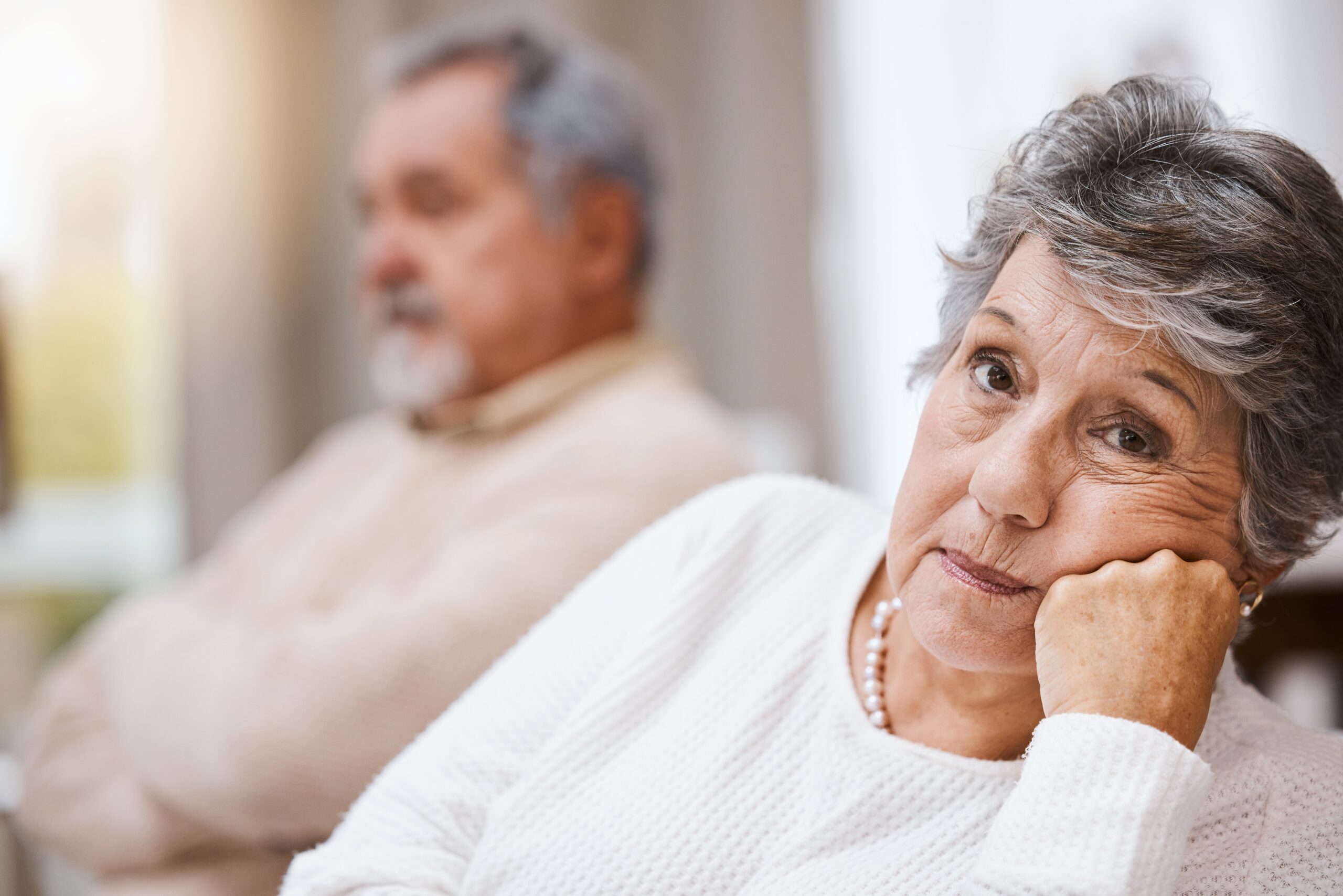 A senior couple sitting at home during a difficult conversation.