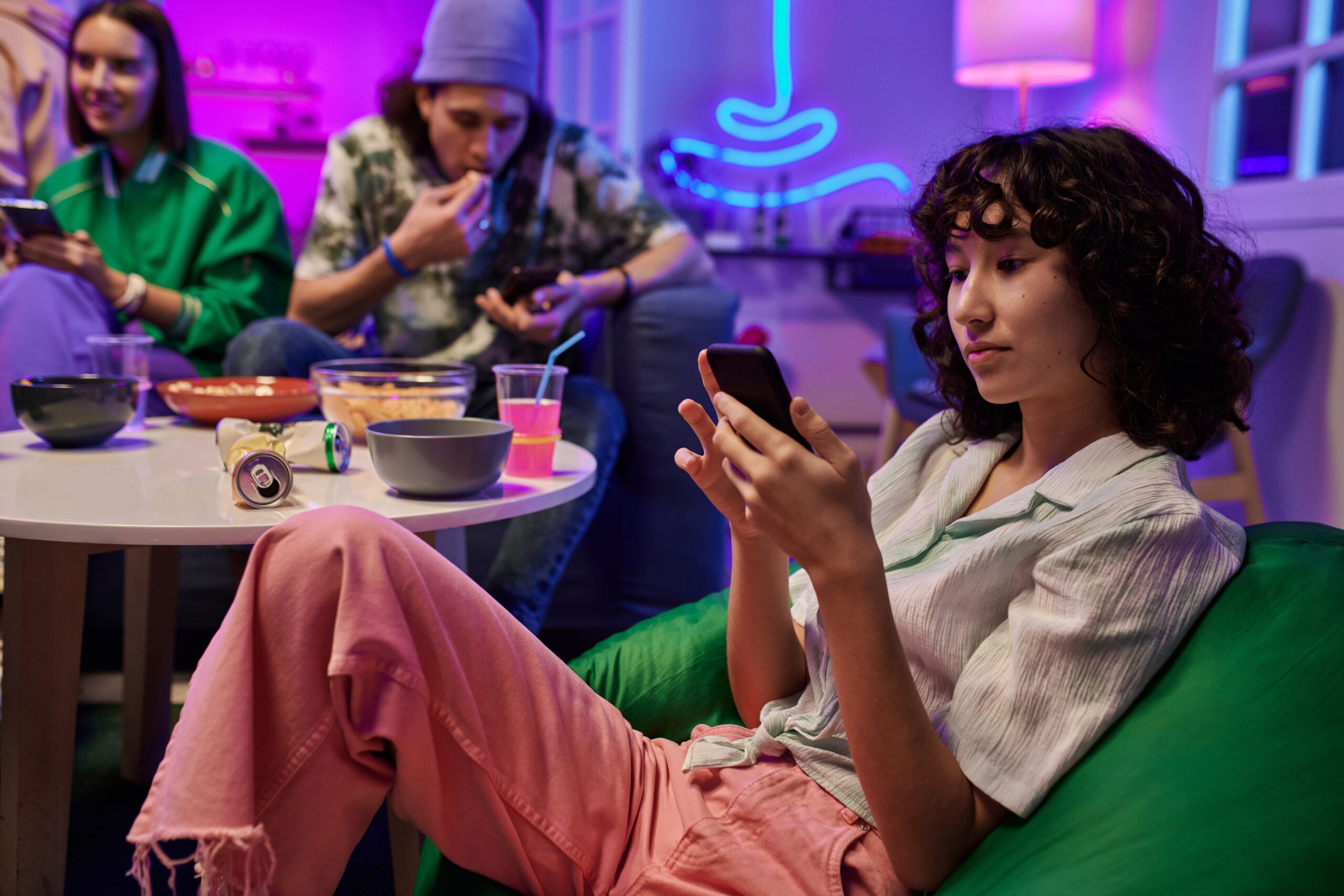 Gen Z friends on their phones at a party.