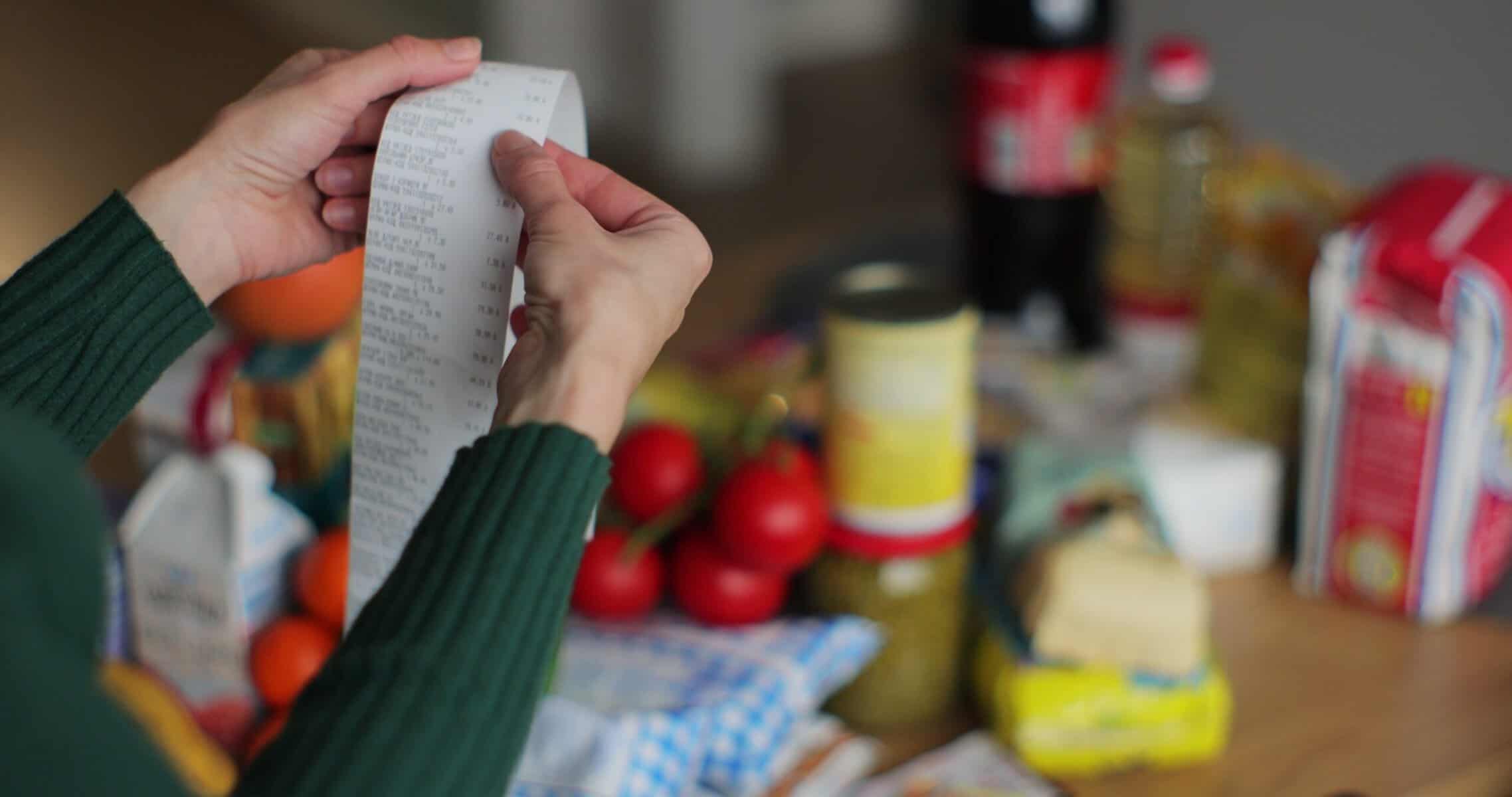 A woman checking the receipt of her grocery bill.