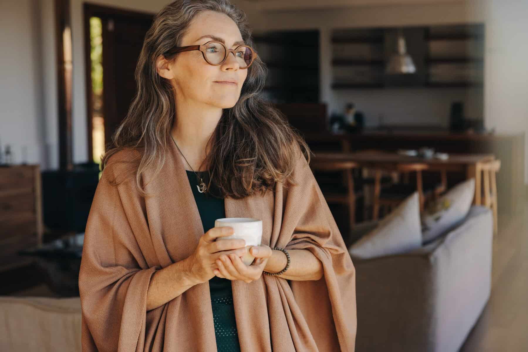 A middle aged woman enjoying time alone with a cup of tea.