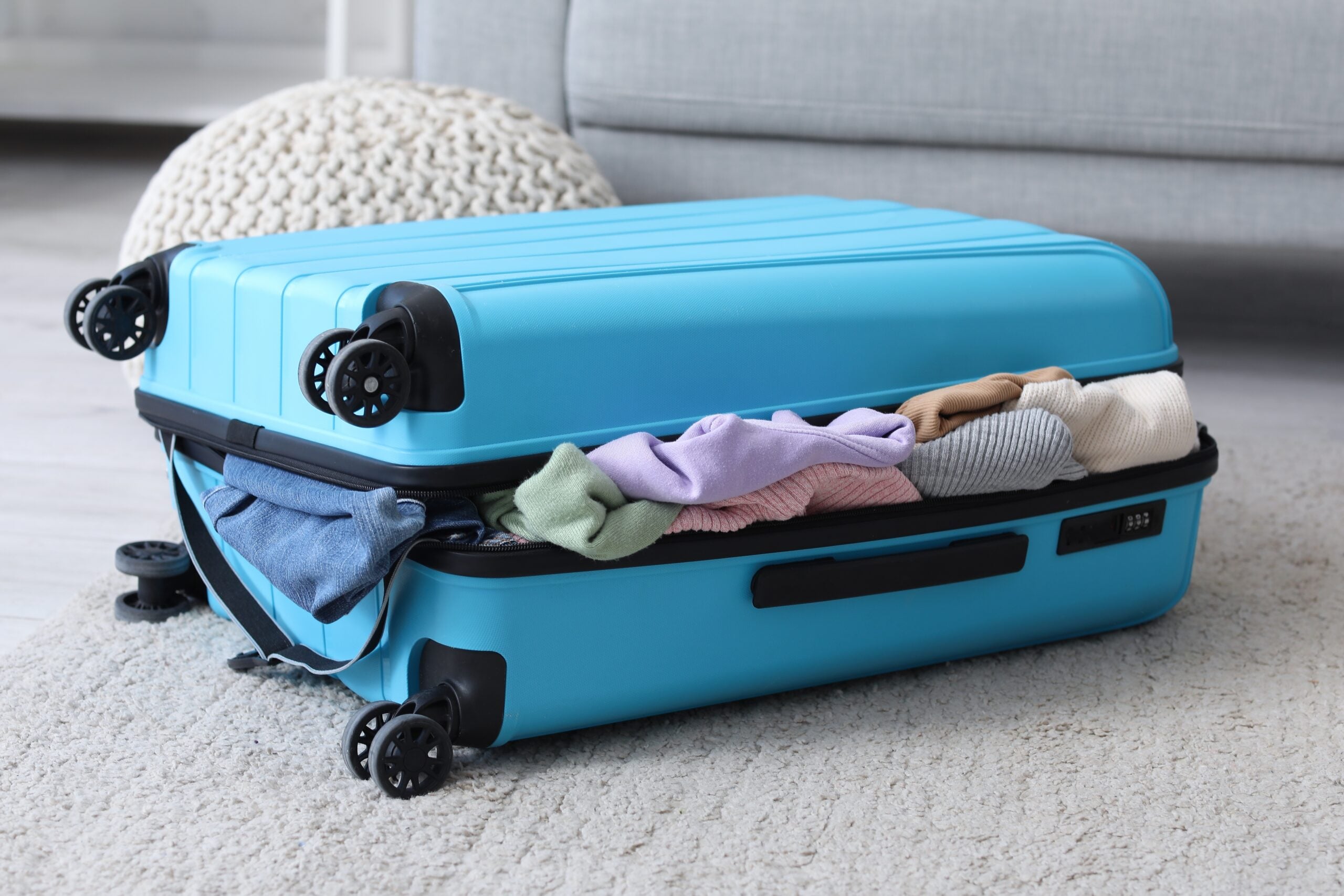 An overflowing suitcase on the floor.