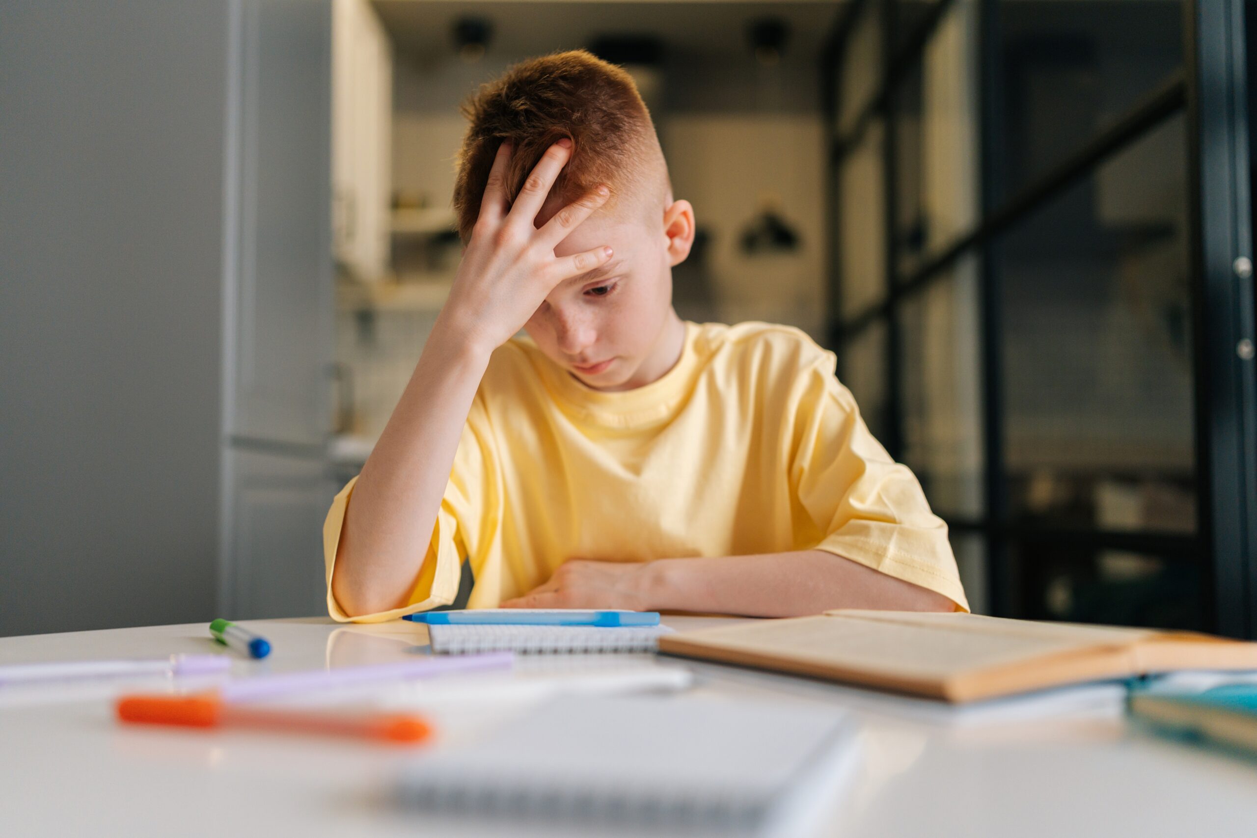 A studious young boy struggling through schoolwork on his own.