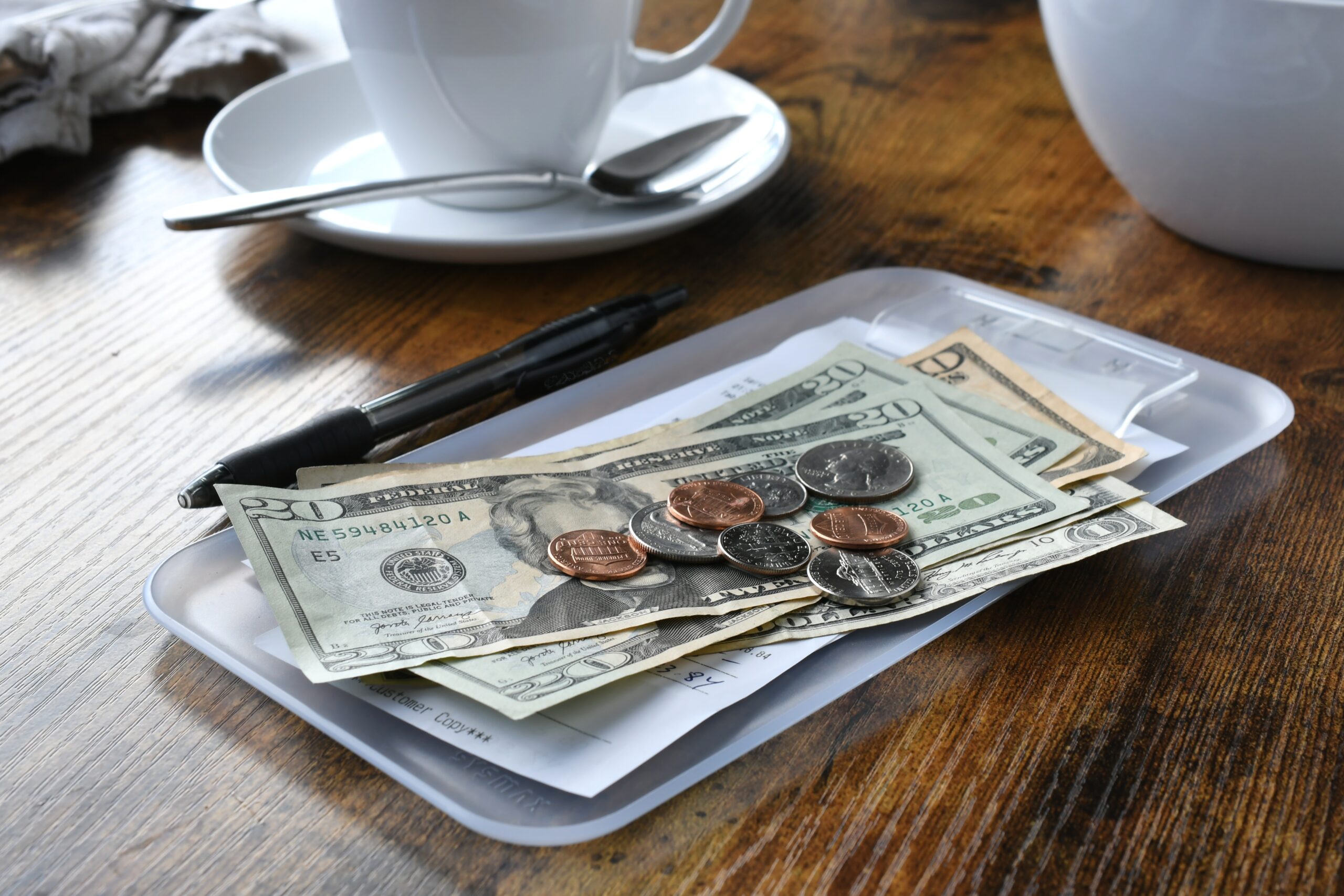 A bill plus tip paid in cash at a diner.
