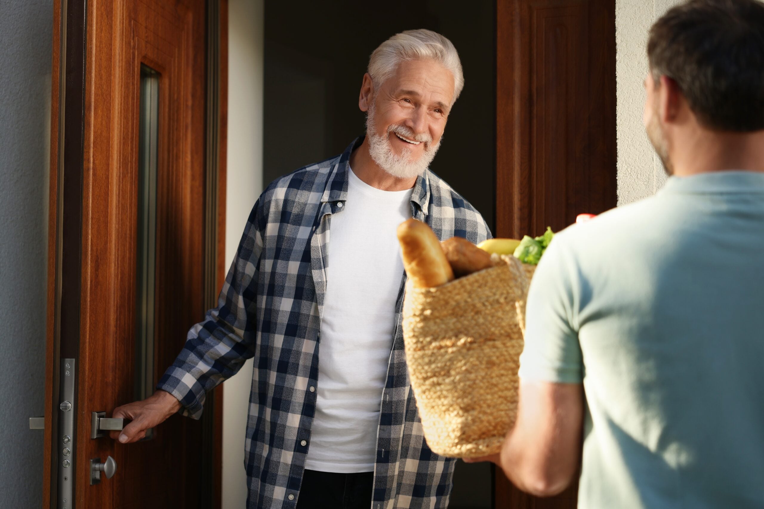 A man bringing groceries to his neighbor.