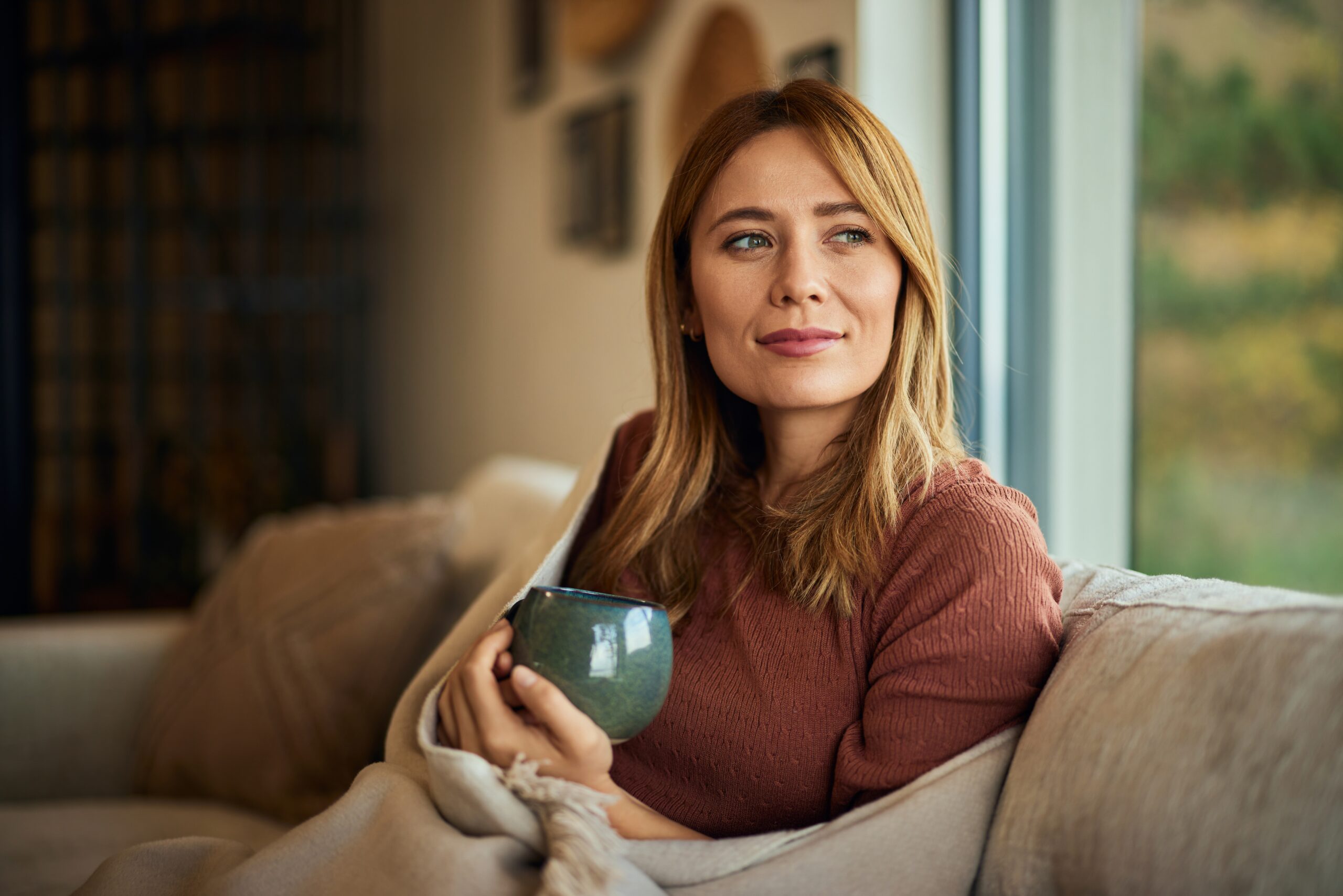 A friendly woman sitting alone with a cup of coffee.