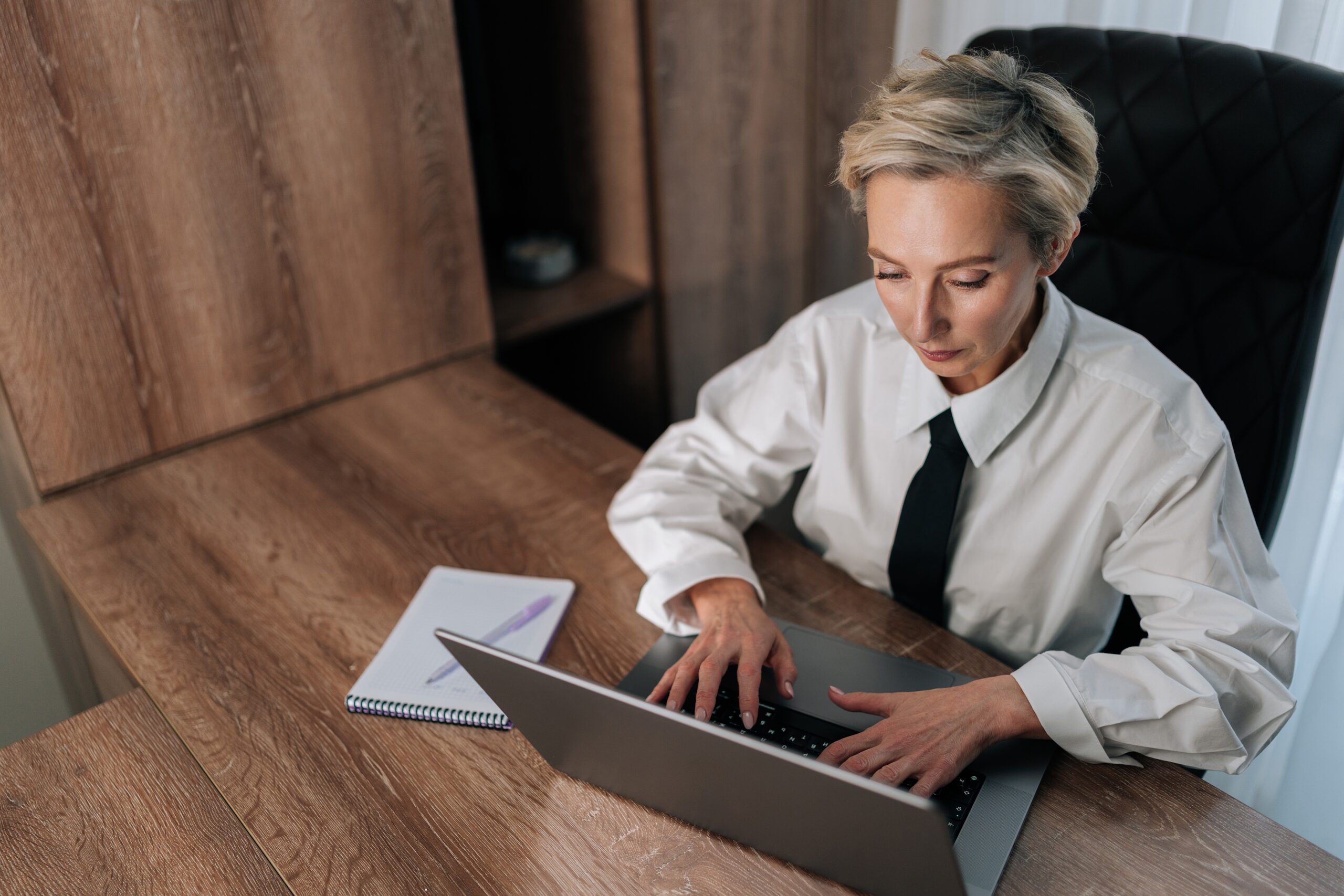 A middle-aged professional business woman sitting at her desk.