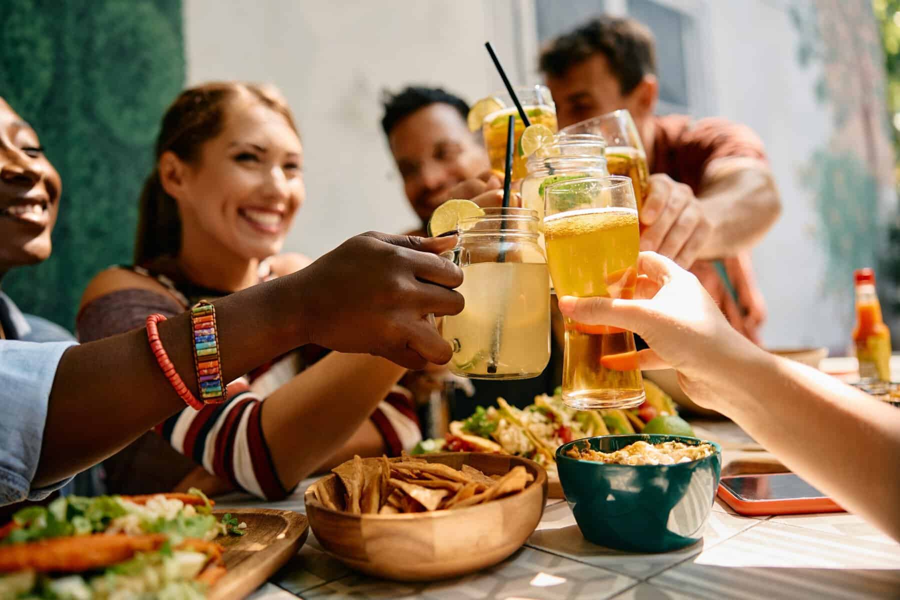 A group of friends celebrating and toasting during a lunch in restaurant.
