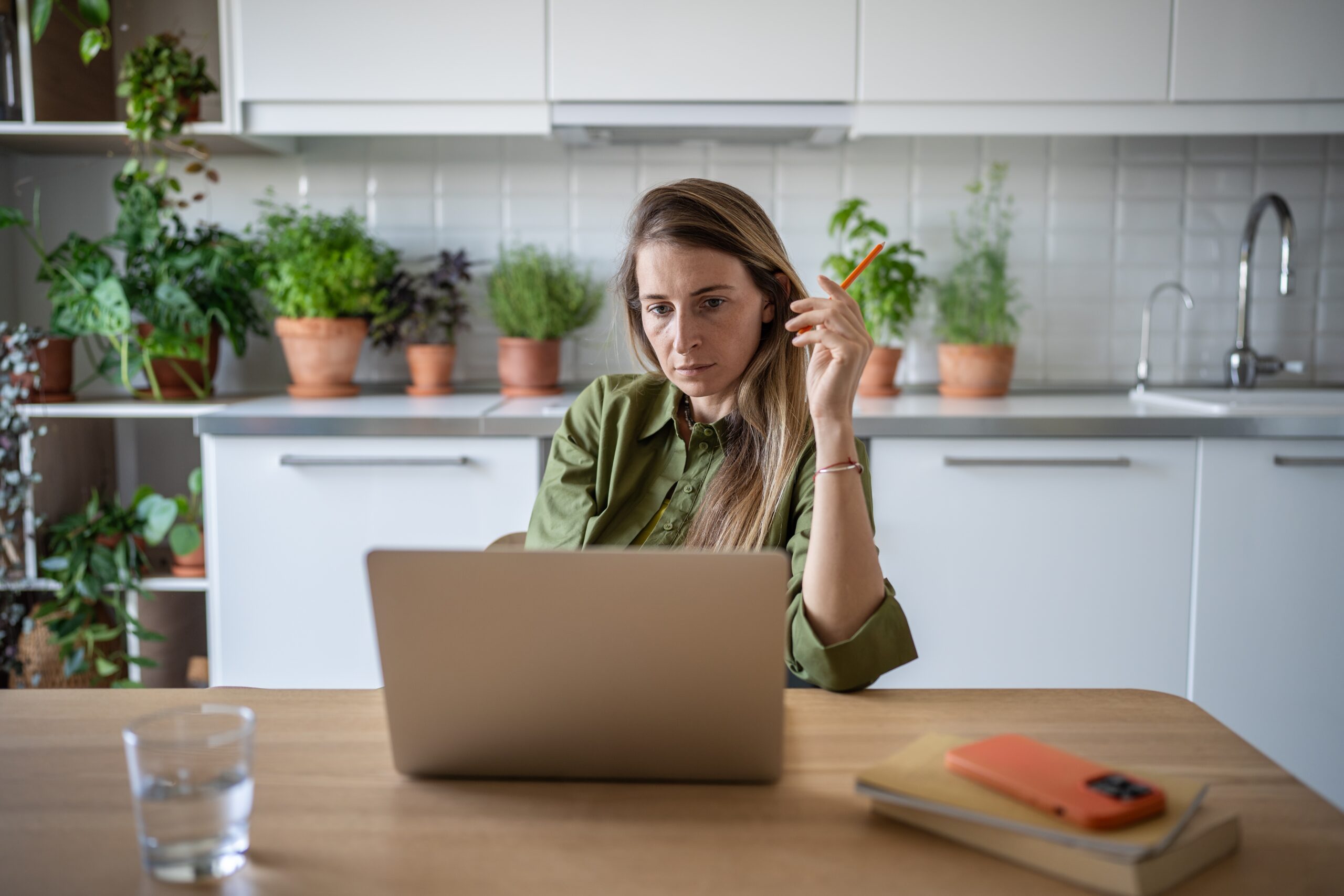 An independent woman paying bills at the kitchen counter.