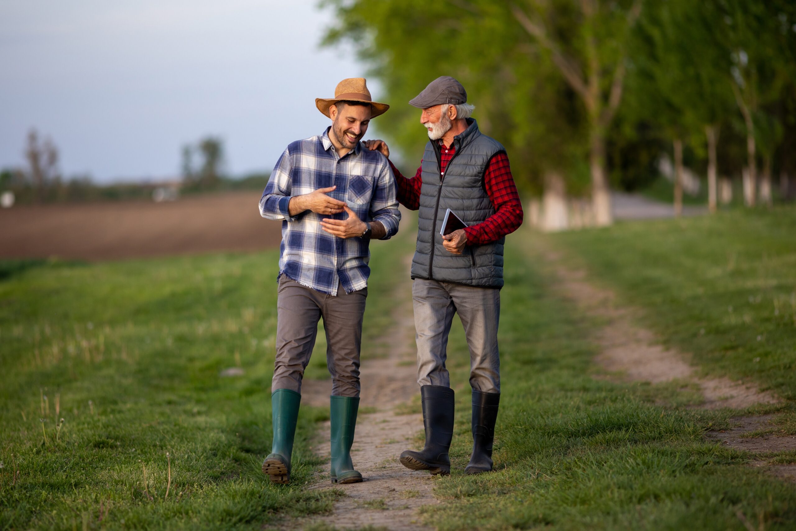 Senior father on a walk outdoors with his adult son.