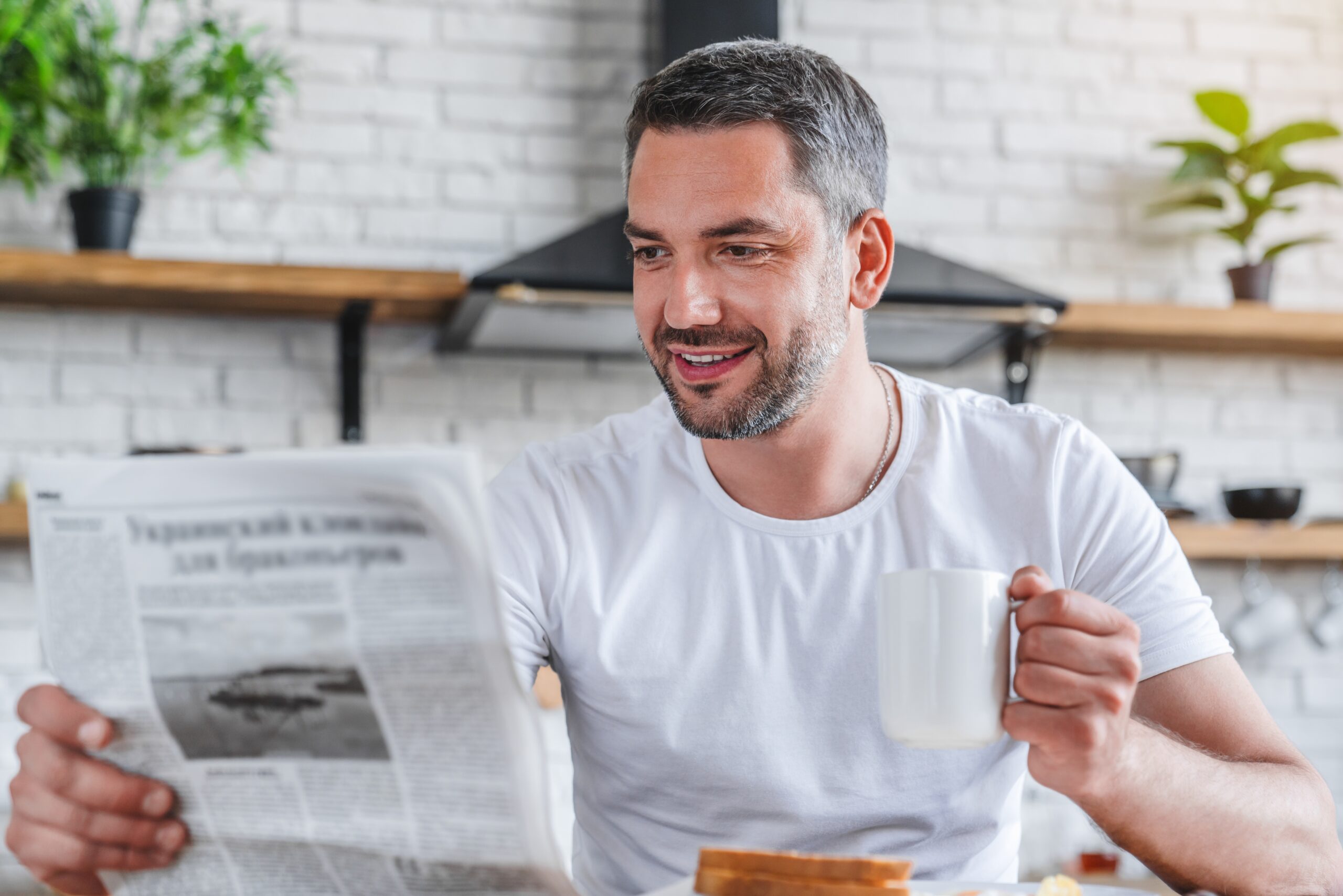 A man starting his day by reading the newspaper.