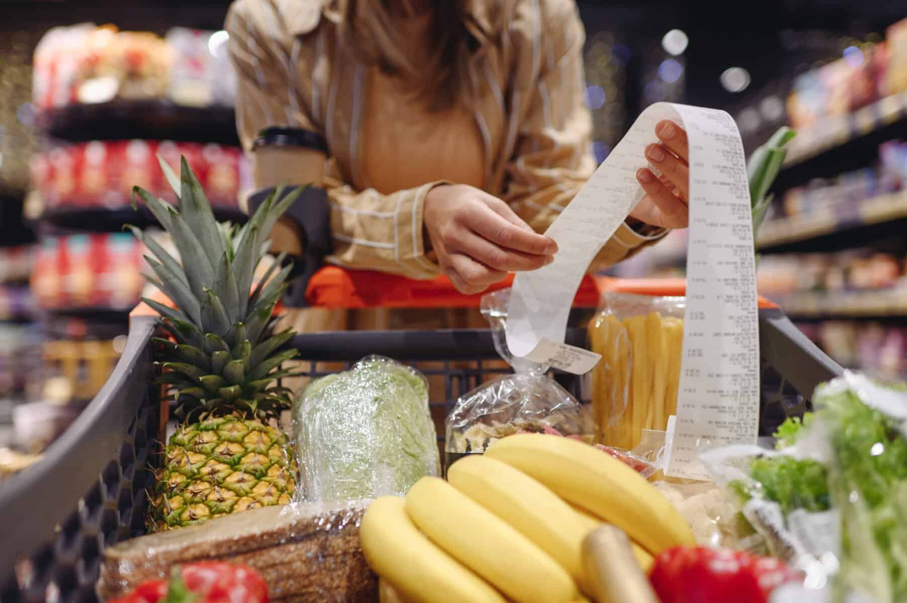 A woman checking the receipt of her grocery bill.