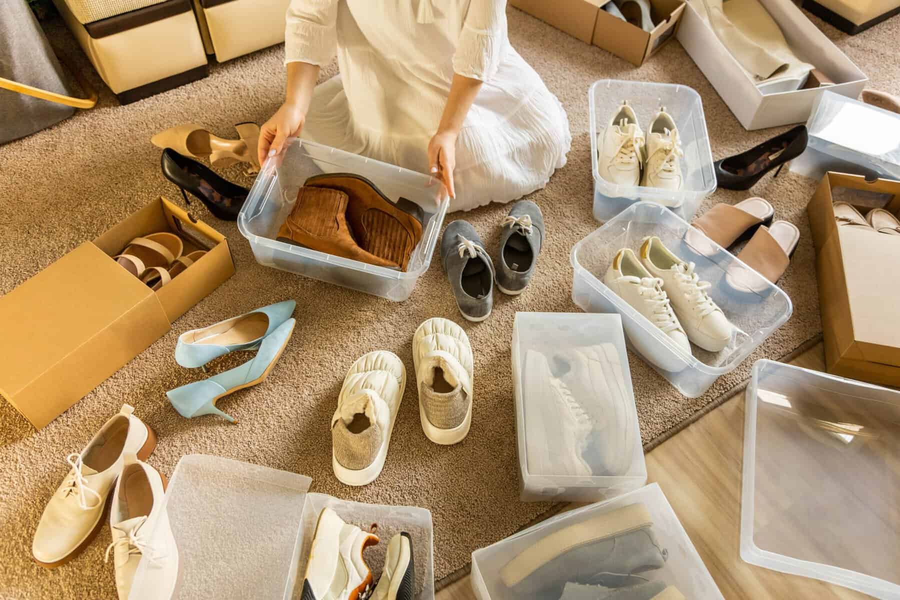 A woman arranging her shoes into plastic containers.