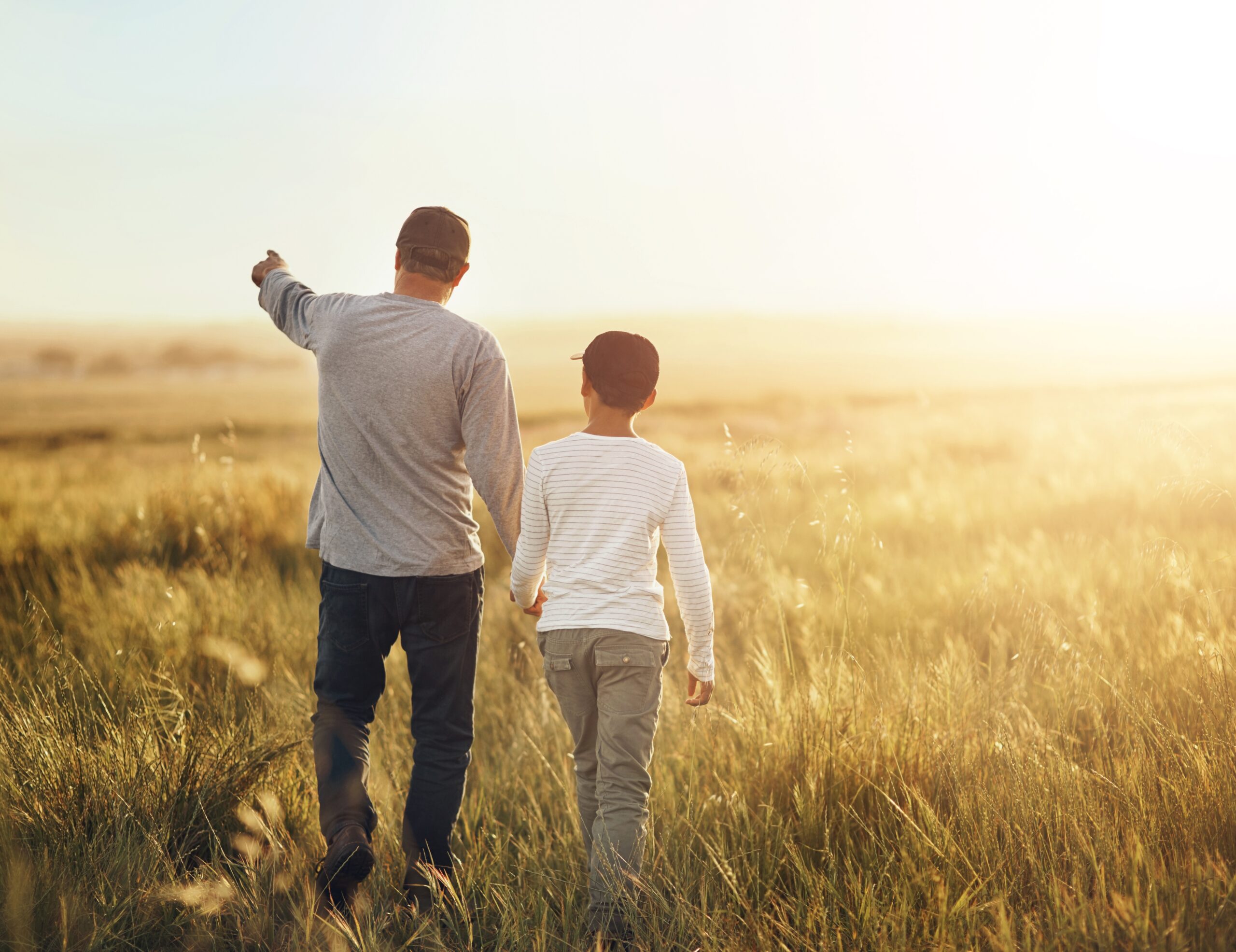 Father and son on a nature walk at sunset.