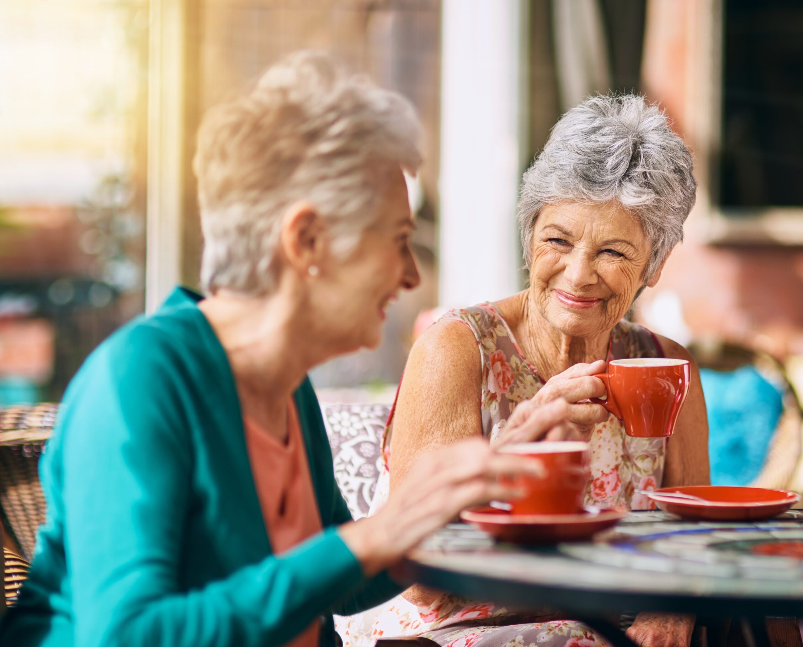 Senior women smiling in a cafe having coffee together.