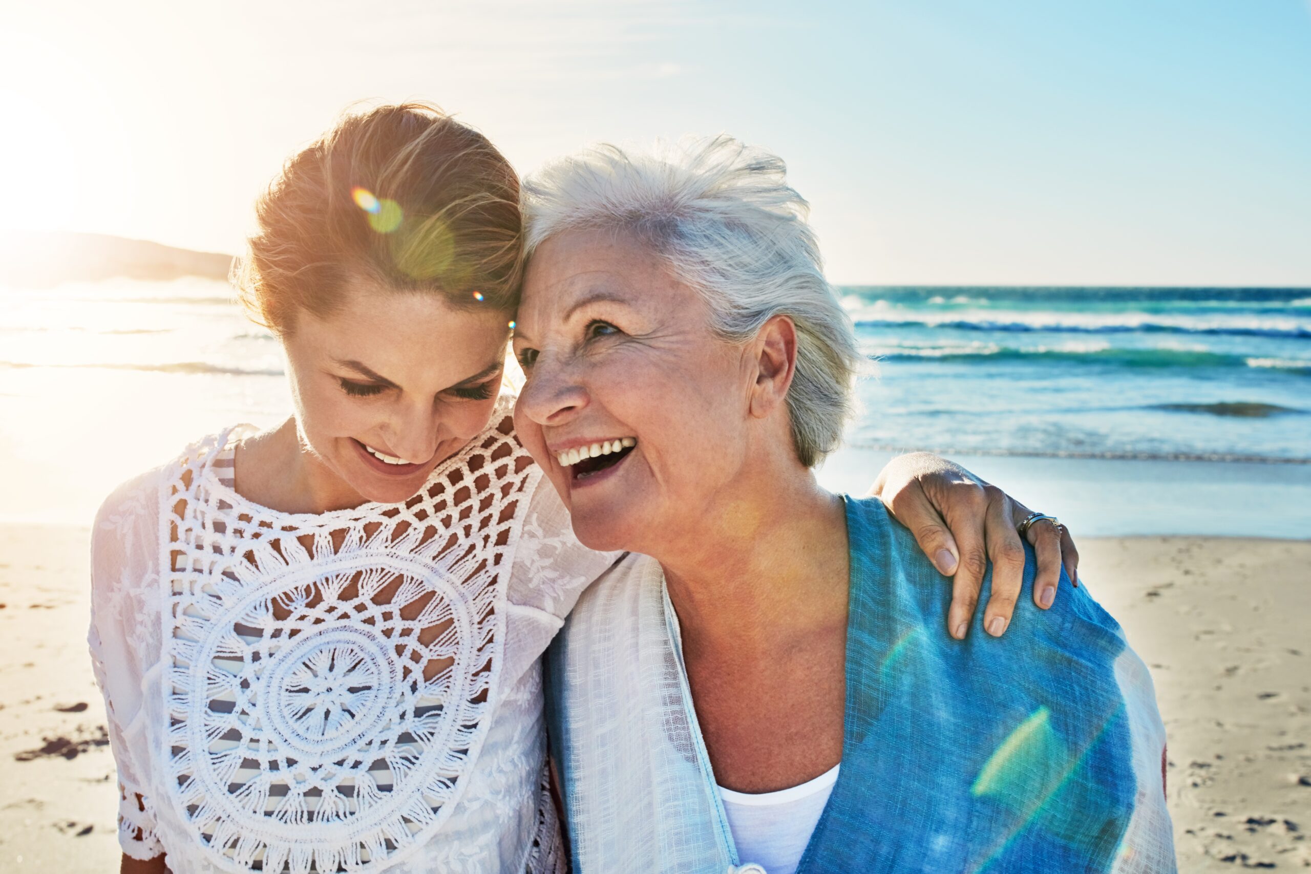 A senior mother with her adult daughter on a walk at the beach.