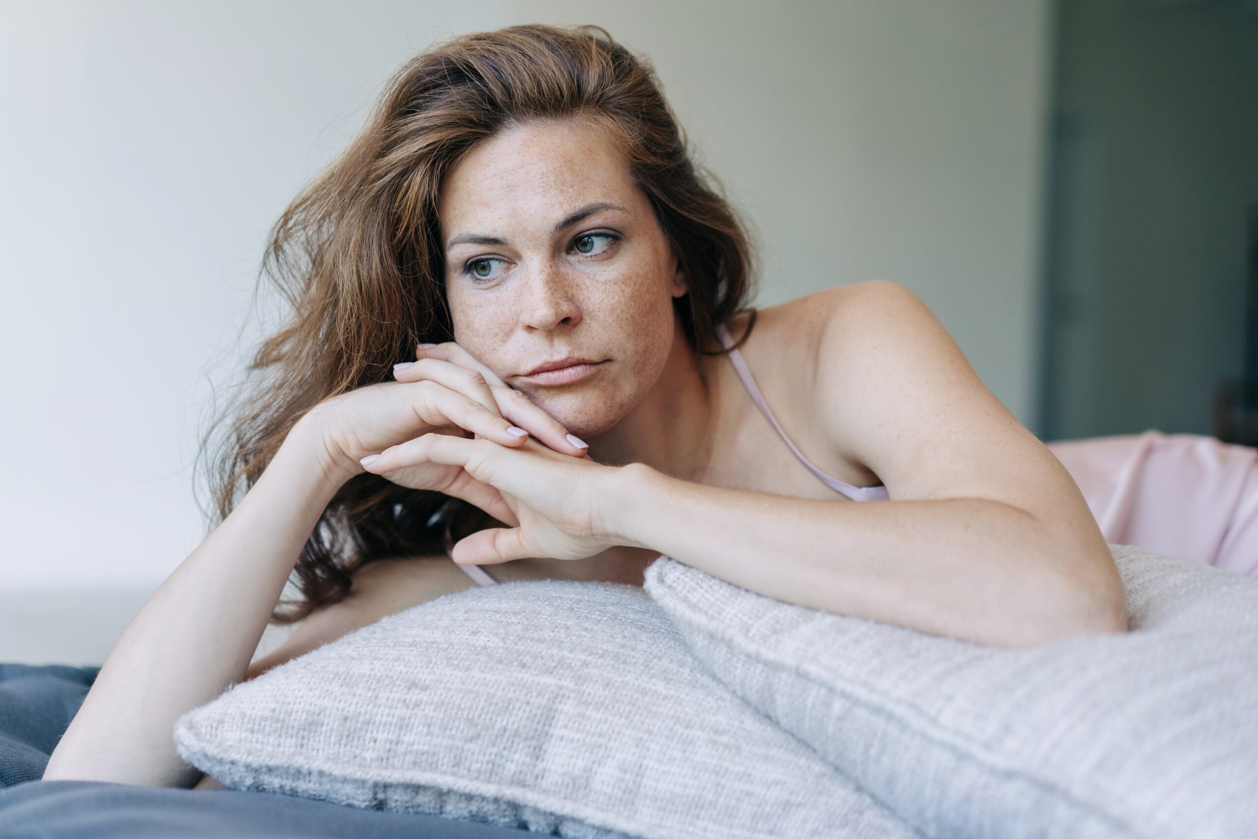 A woman deep in thought alone at home.