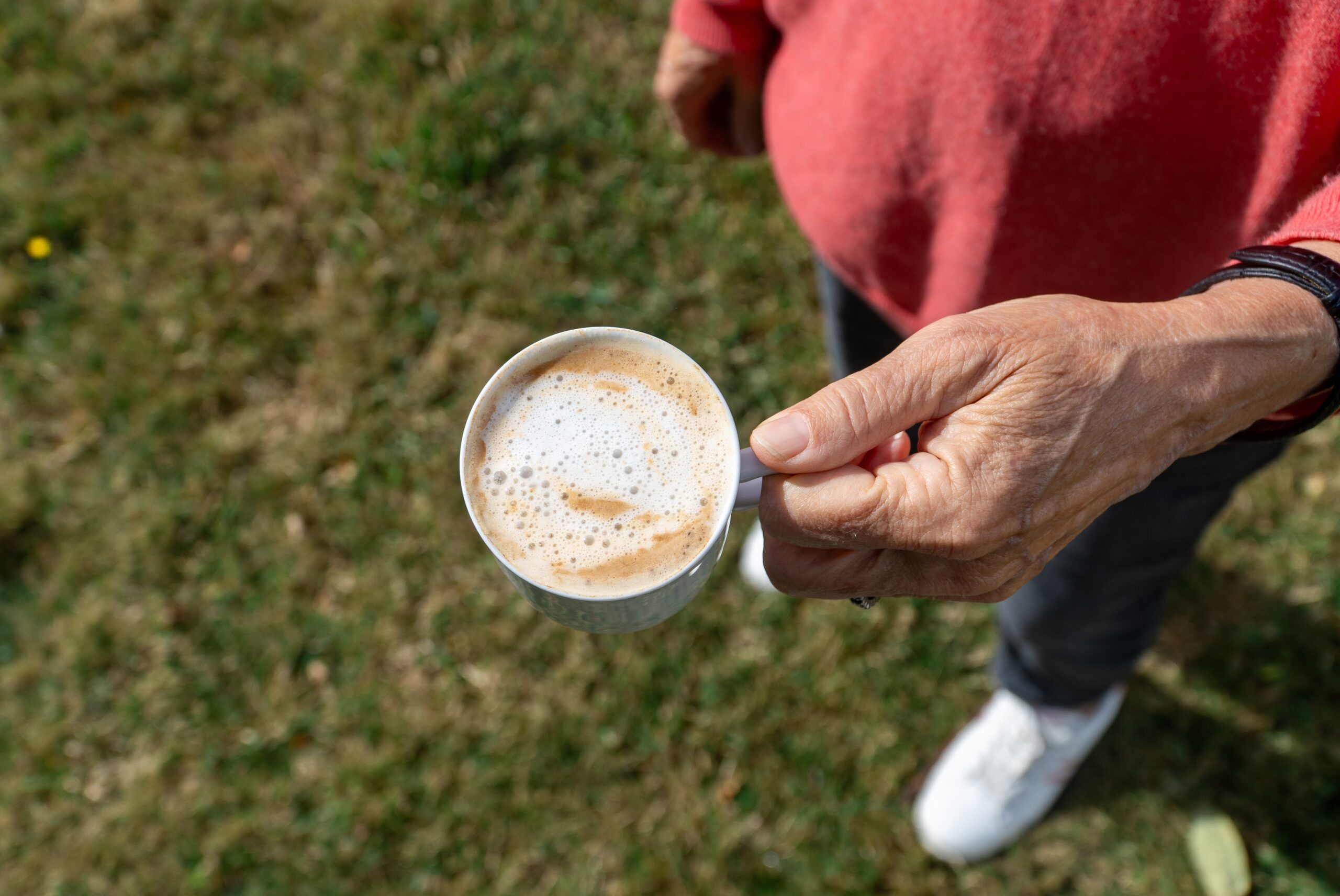 A senior man having his morning coffee outdoors.