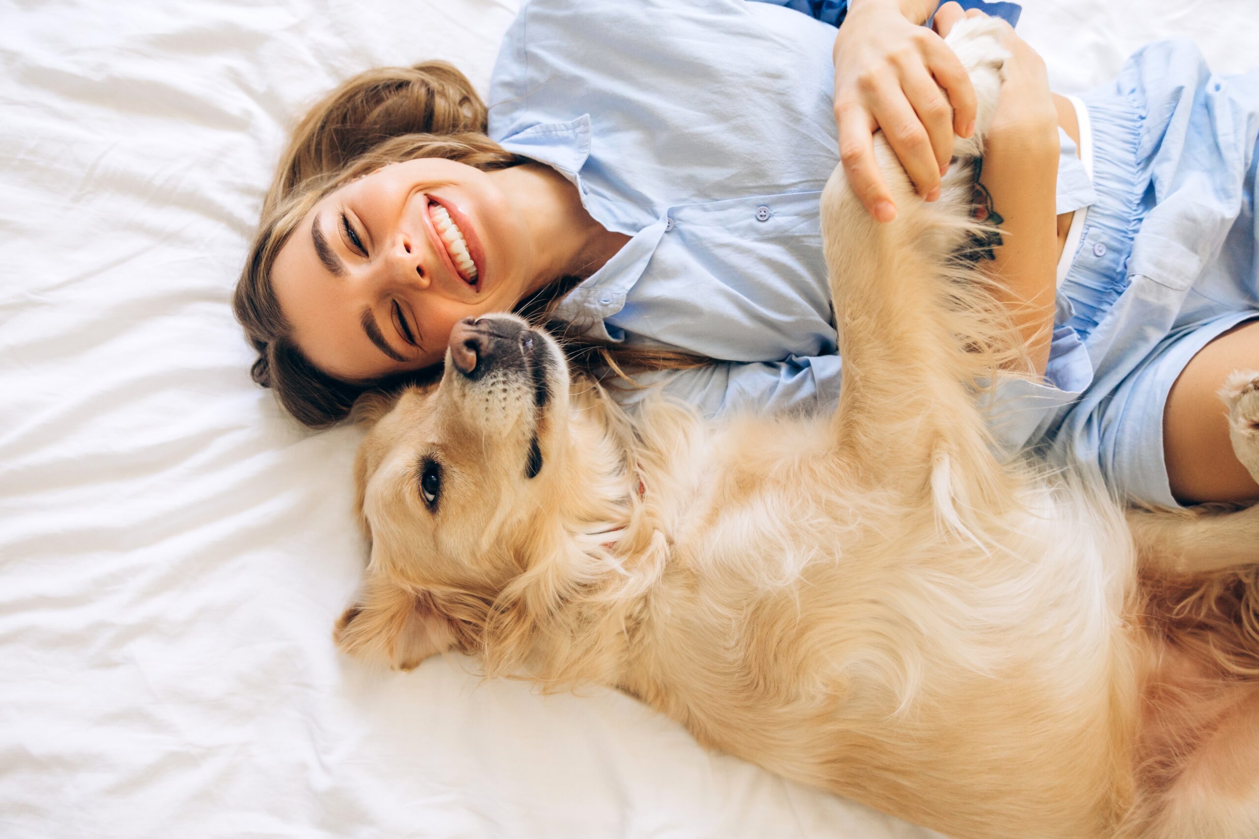 A woman laying happily with her beautiful dog.