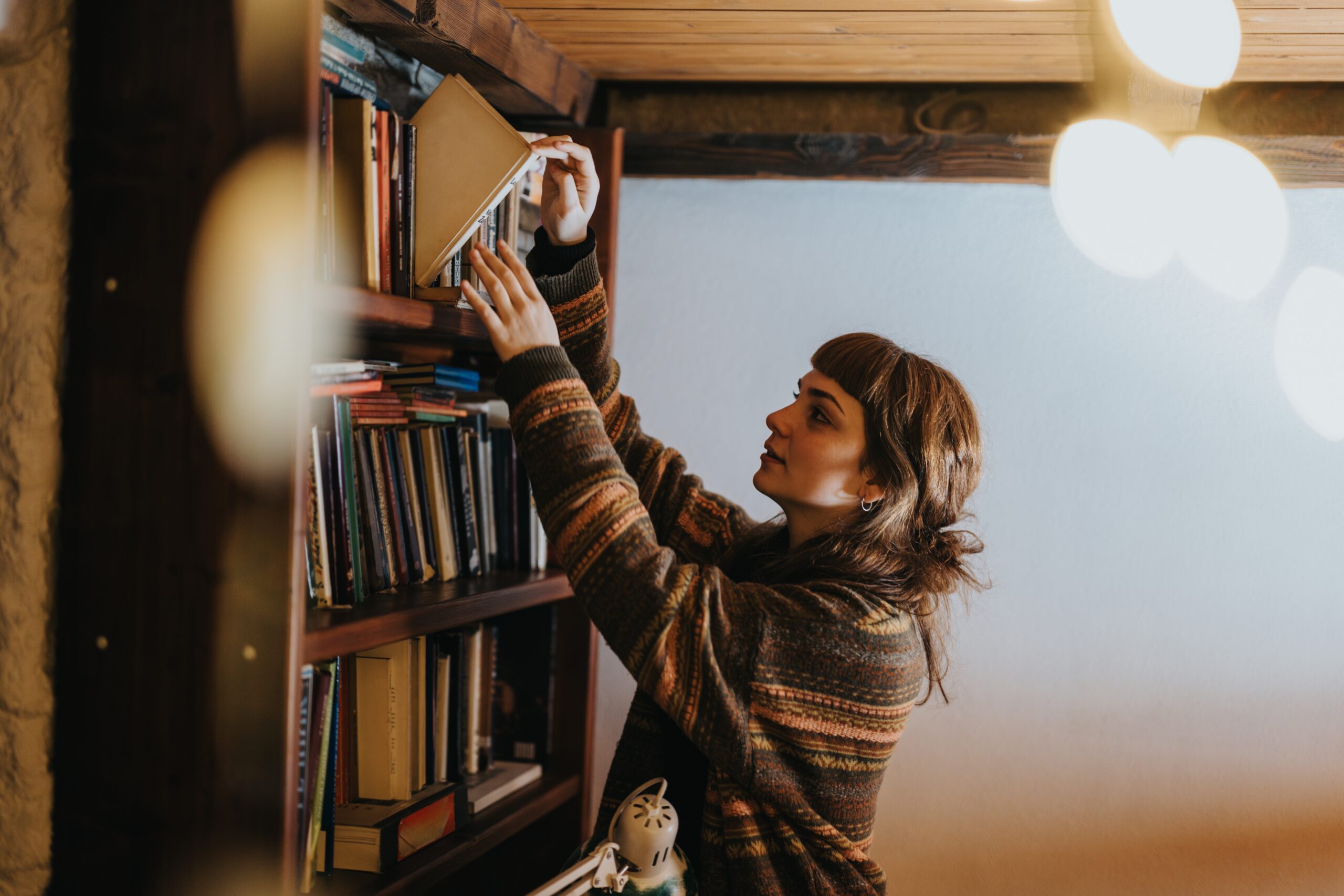 A woman who lives alone arranging her bookshelf.