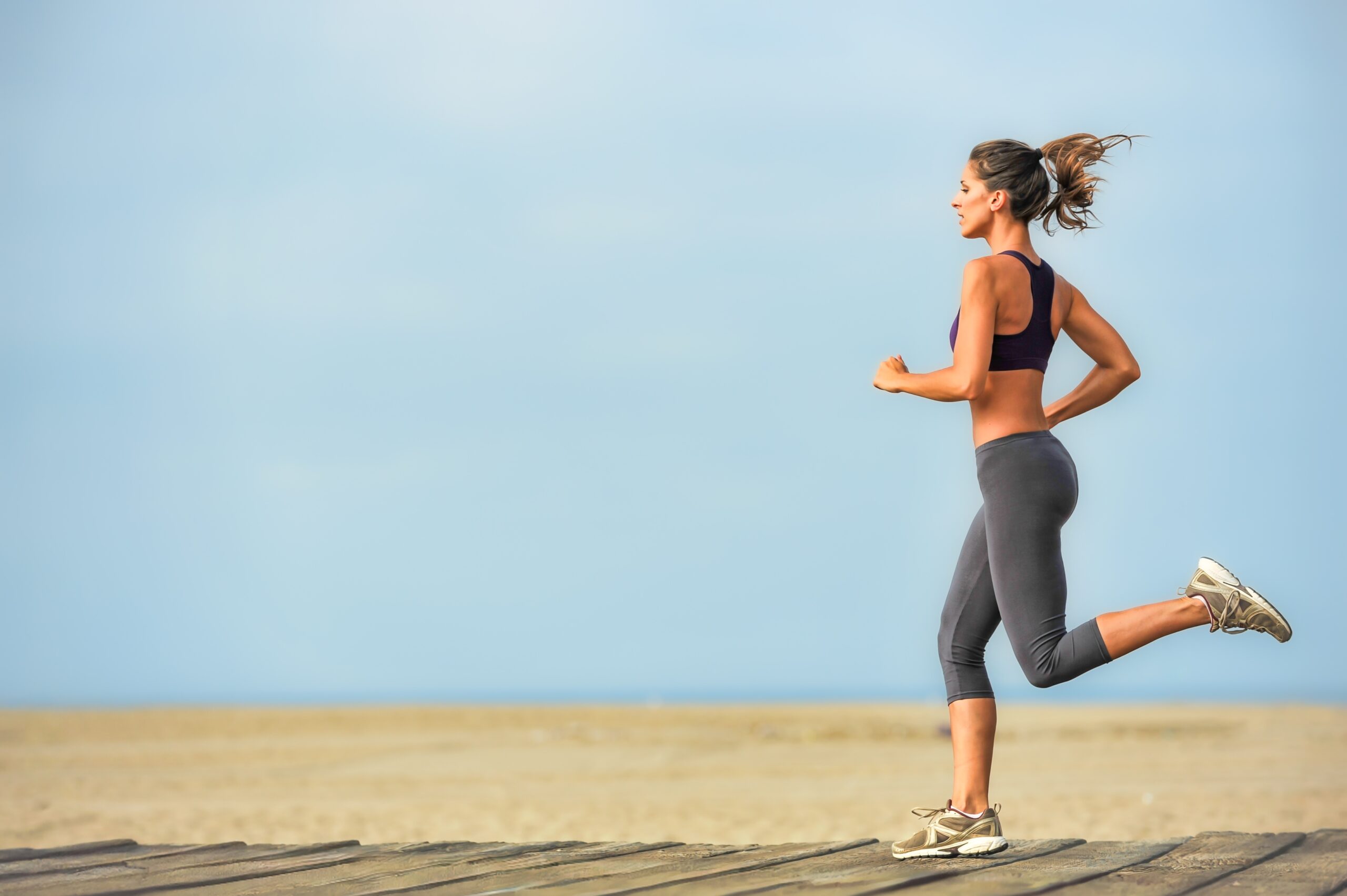 A woman running on the beach during her vacation.
