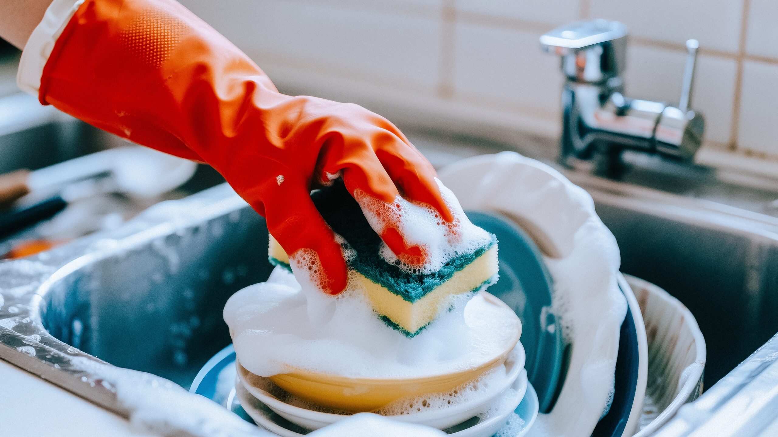 A woman washing dishes after dinner.