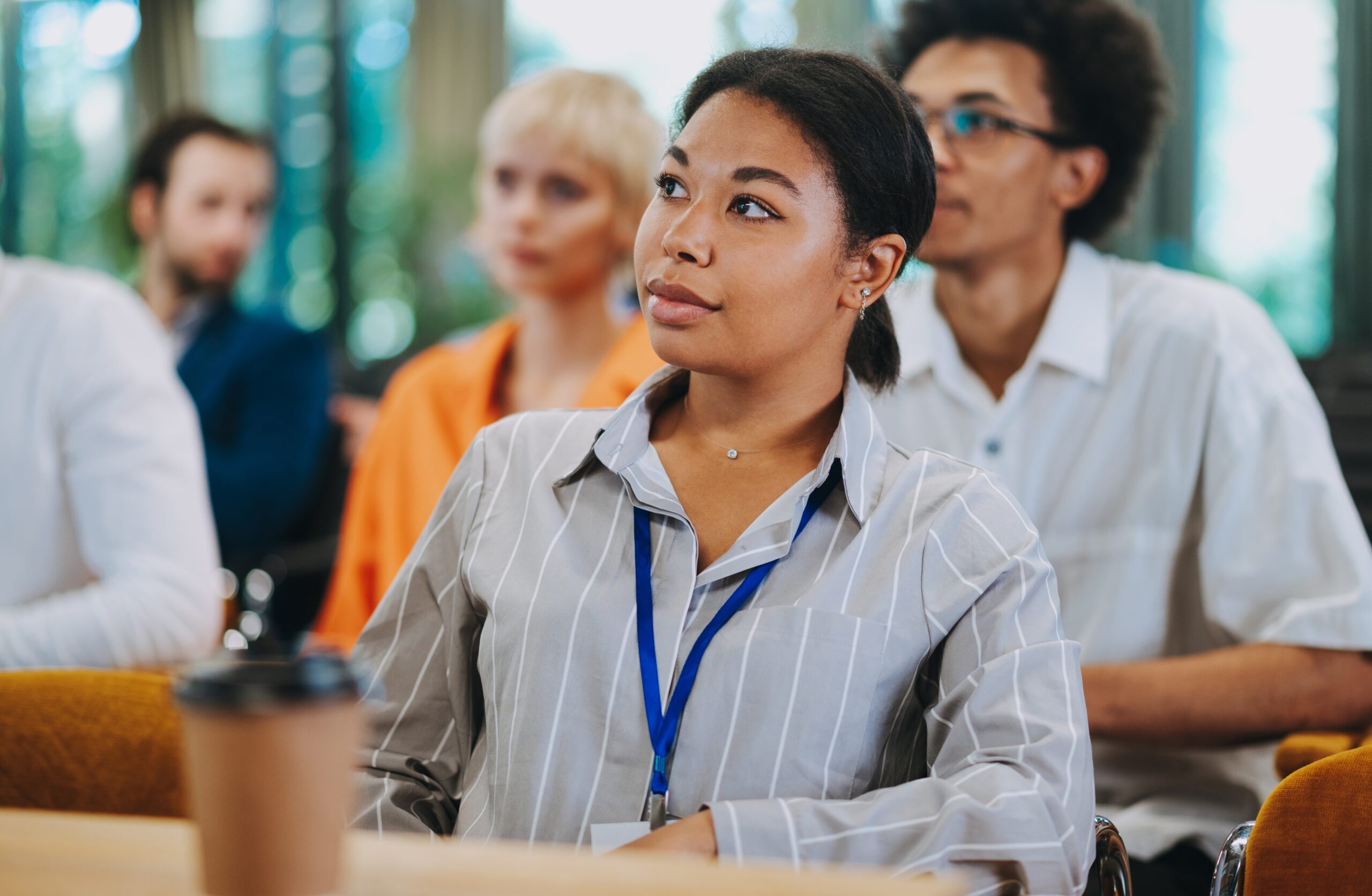 A young woman looking skeptical in a work meeting.